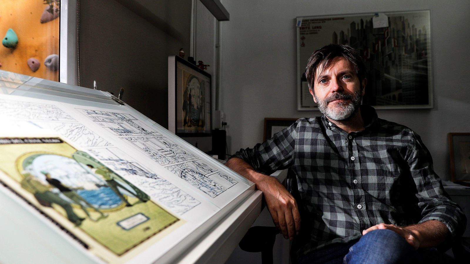 Paco Roca posa en su estudio junto a los bocetos de 'El tesoro del cisne negro'.