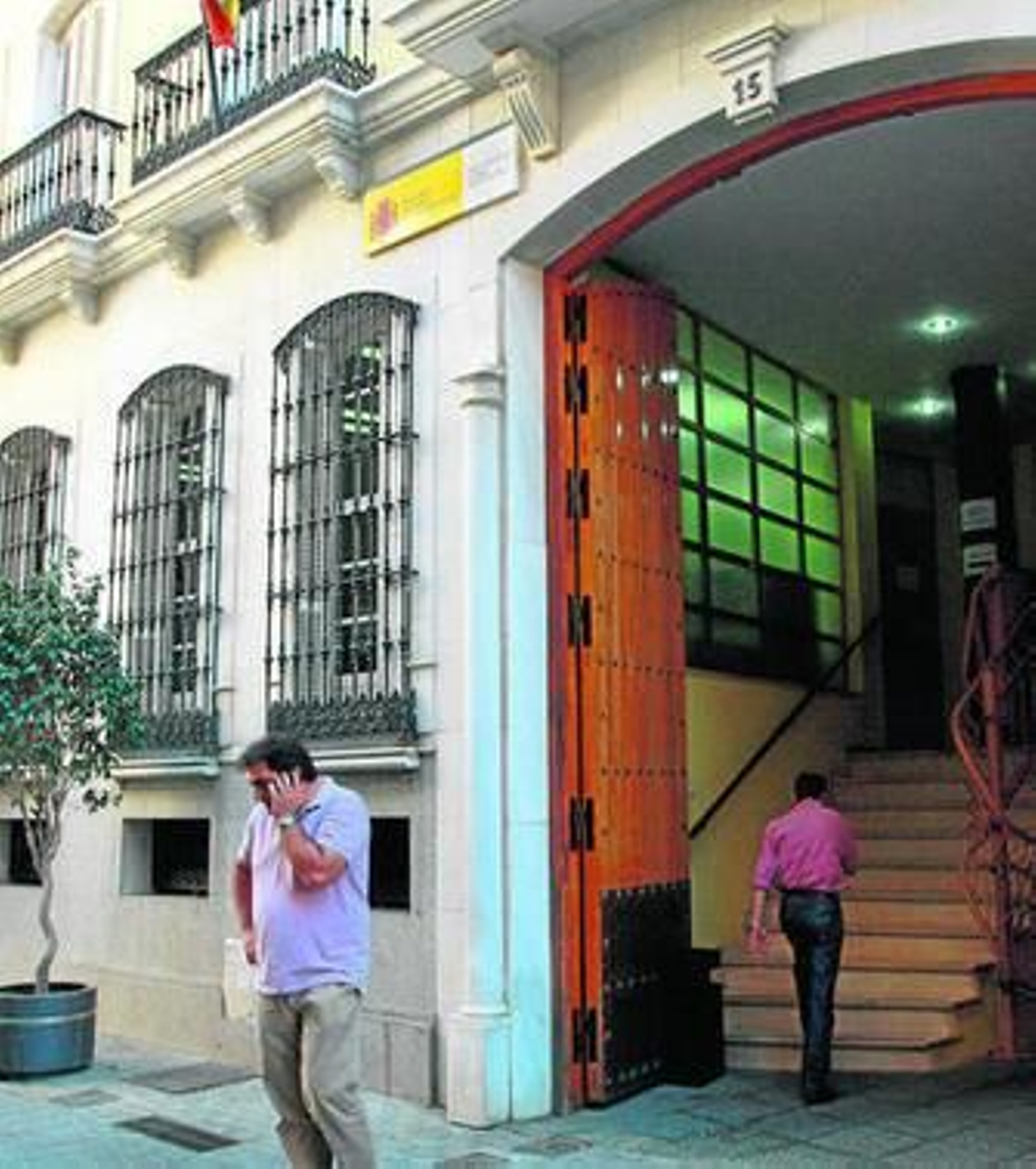 Una persona habla por teléfono delante de la puerta principal de la sede de la Inspección de Trabajo en Huelva. Una persona habla por teléfono delante de la puerta principal de la sede de la Inspección de Trabajo en Huelva.