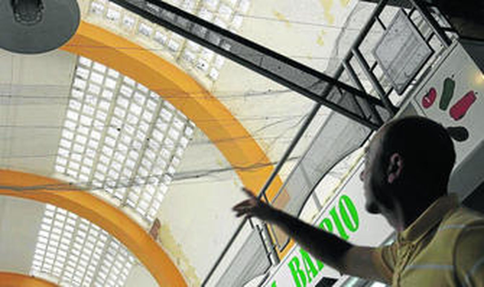 Vicente Torres señala las mallas colocadas por los comerciantes por la caída de cascotes y cristales.