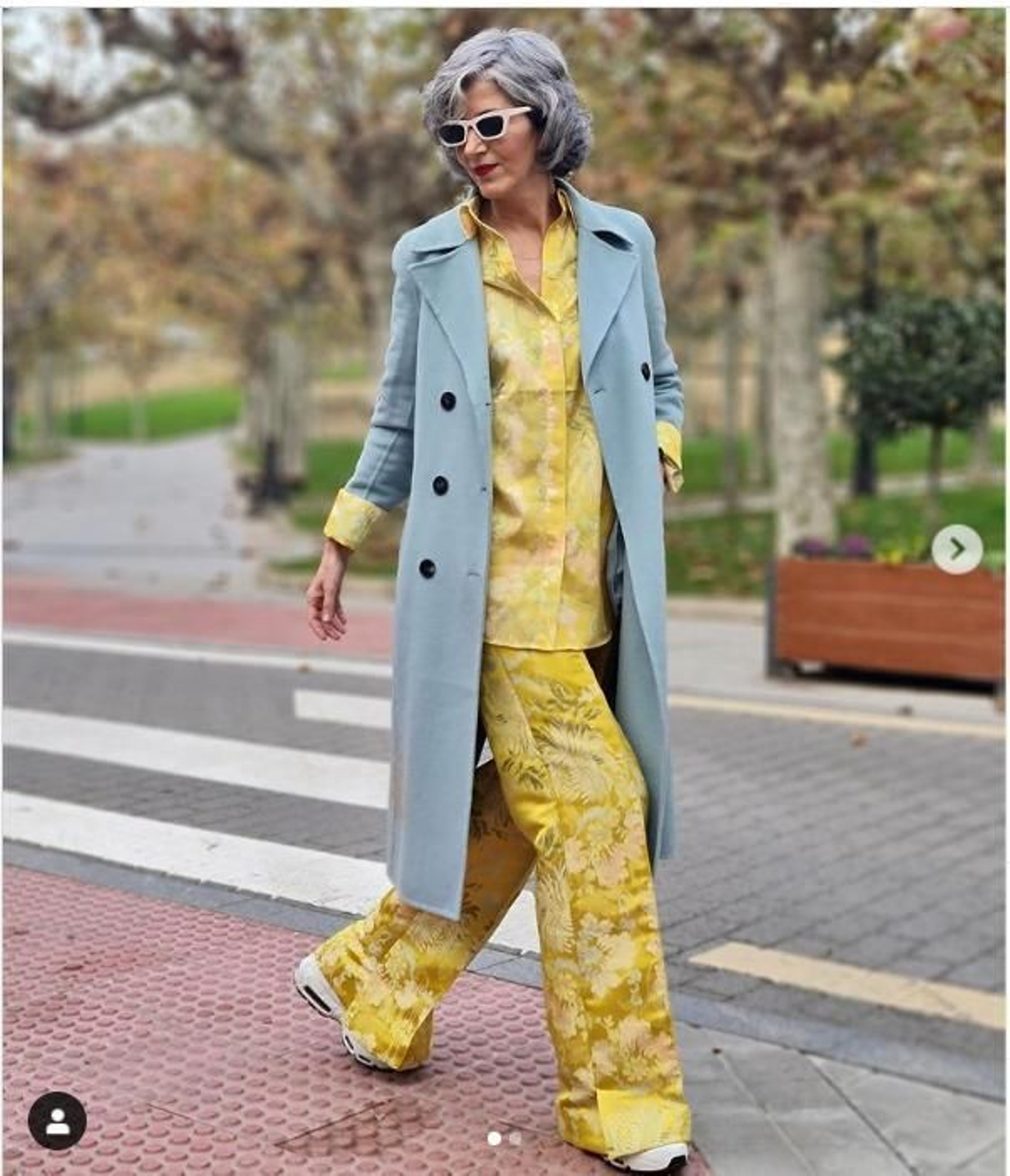 Carmen Gimeno con un conjunto camisero en amarillo y abrigo gris.