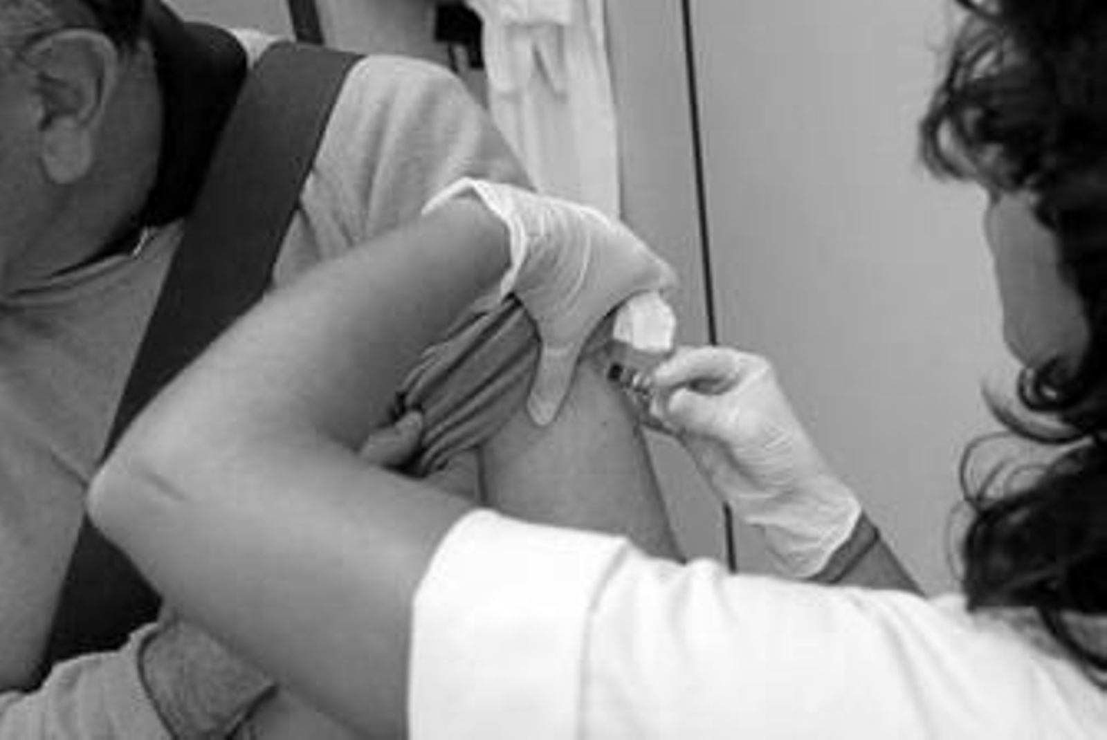 Una enfermera vacuna a un usuario contra la gripe común al inicio de la campaña de vacunación de este año.