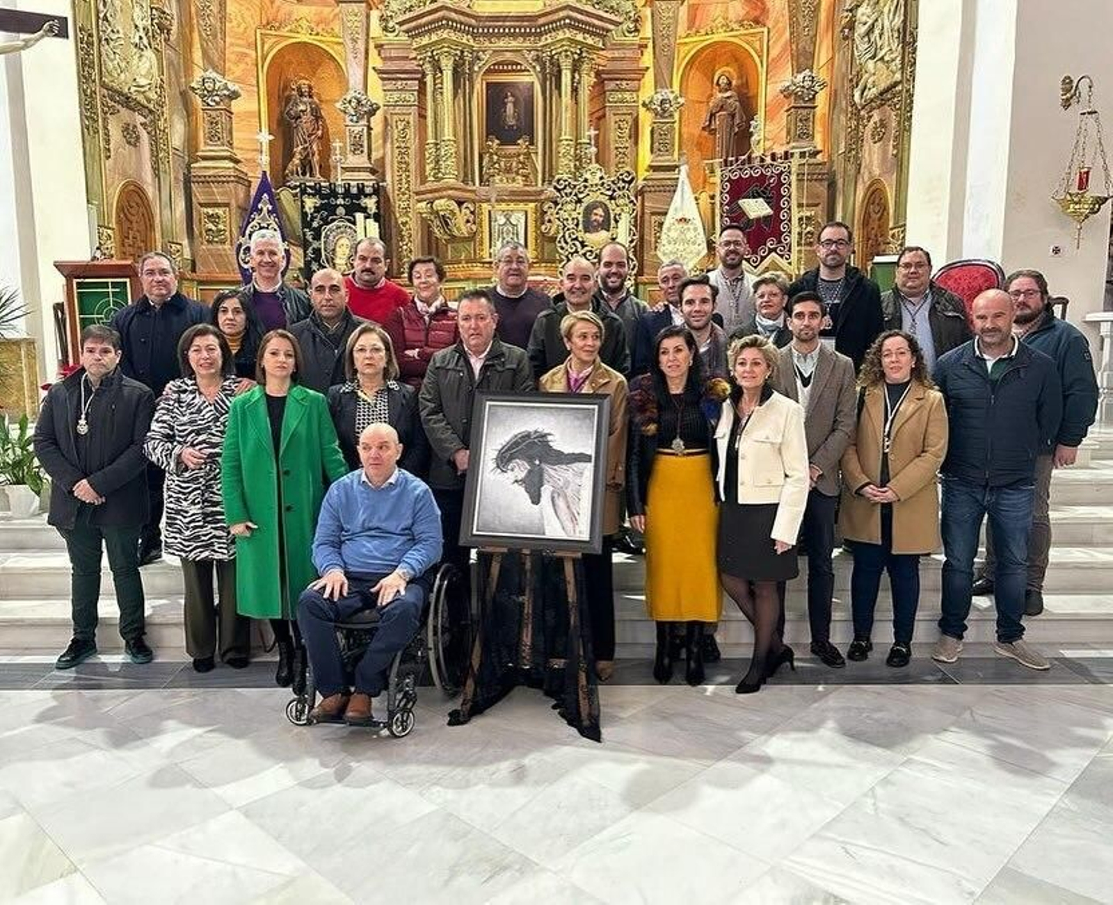 Foto de familia cofrade junto a la imagen del cartel y su autor.