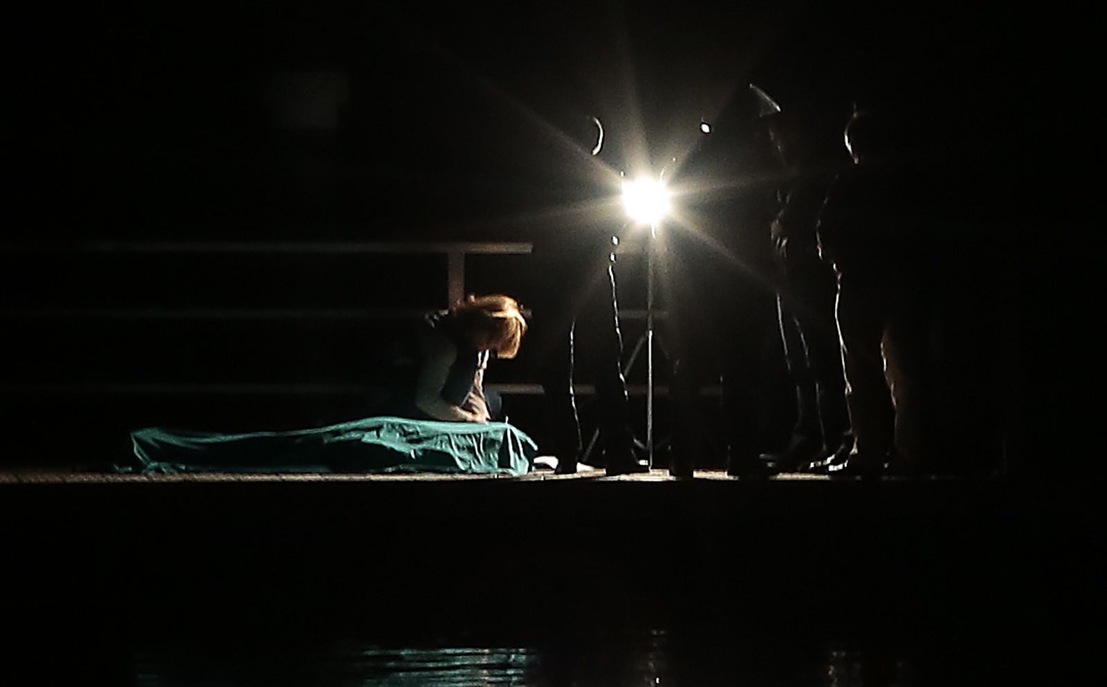 Una forense examina el cuerpo del fallecido.