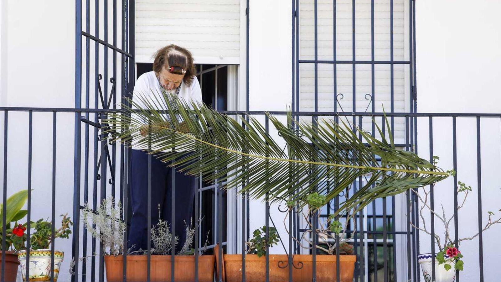 Una mujer en el balcón este Domingo de Ramos
