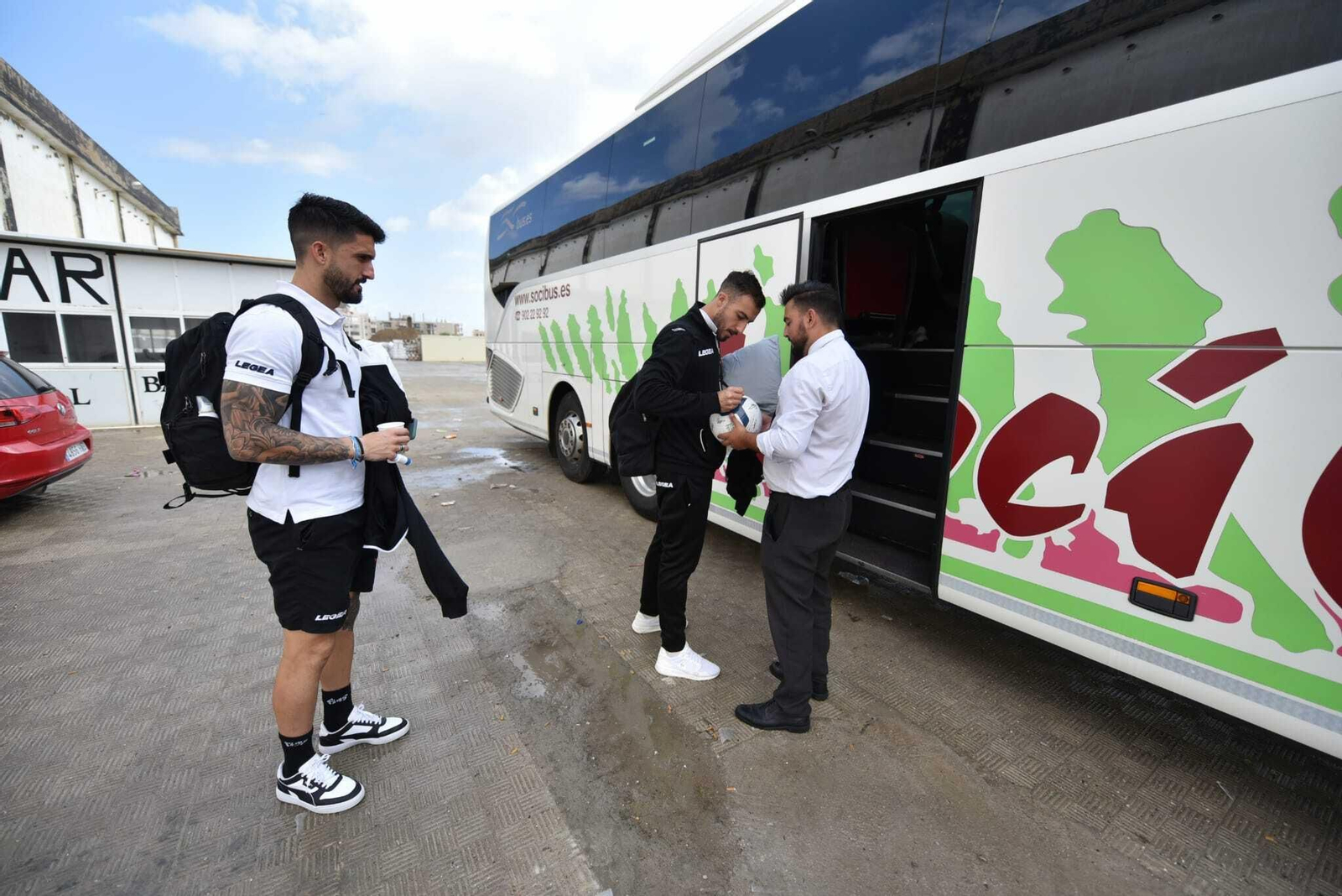 Alberto Varo firma un balón antes de partir, ante De la Calzada
