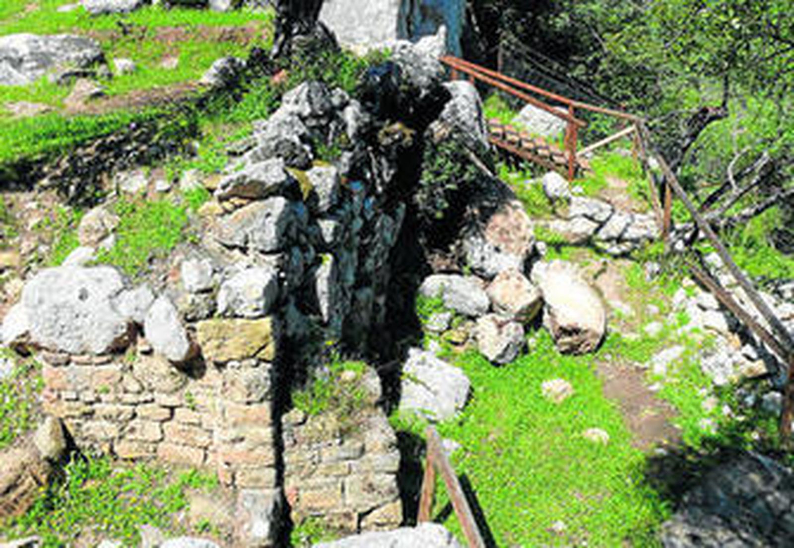 Vista del lienzo que se ha derrumbado, con piedras diseminadas por distintas partes del emplazamiento.