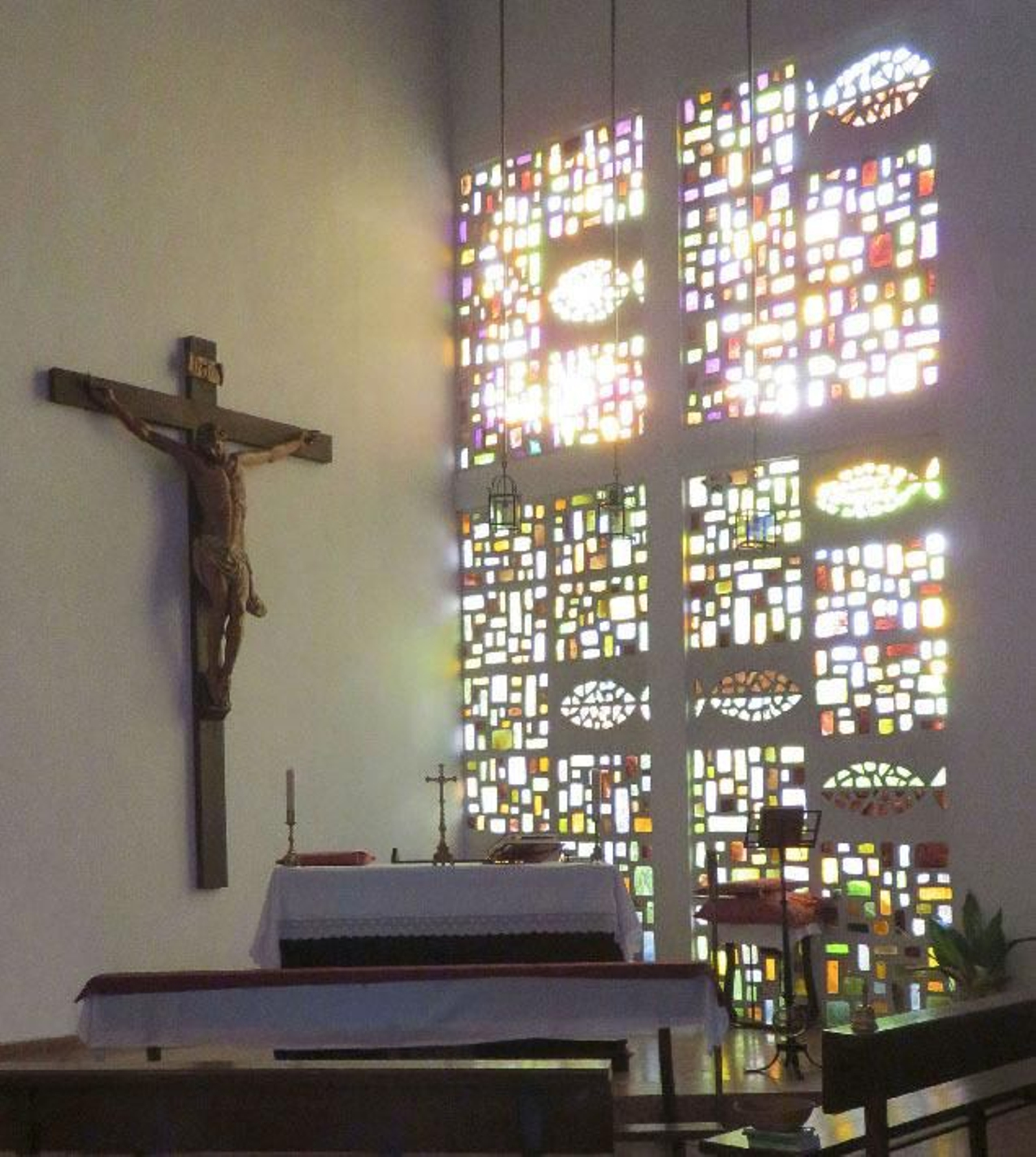 La gran vidriera expresionista-abstracta y el Cristo de la iglesia de Sacramento.