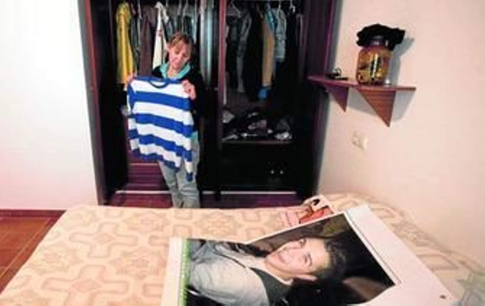 Milagros Vargas mira la fotografía de su hijo, colocada encima de la cama de éste.