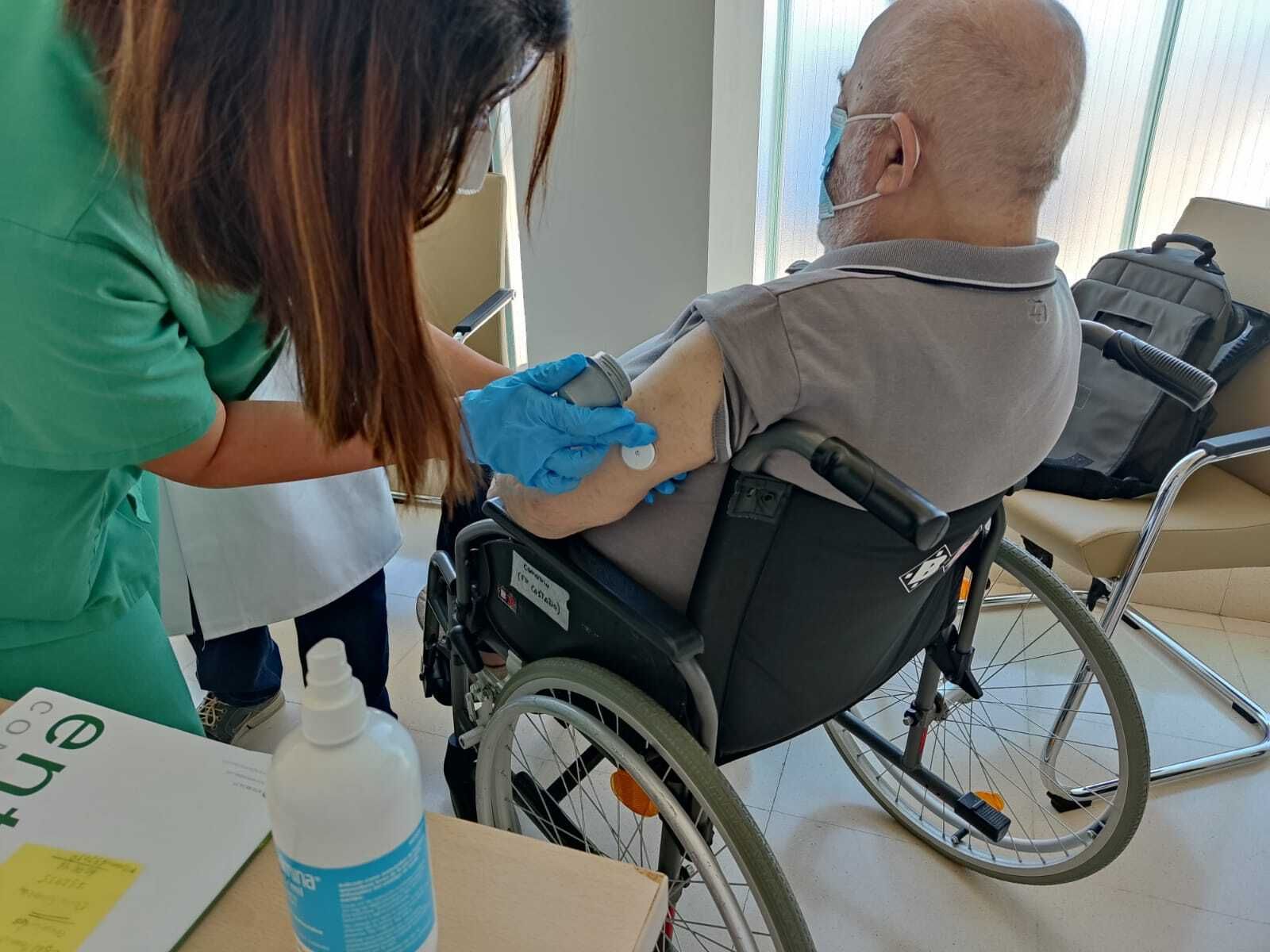 Una enfermera implanta a un paciente el dispositivo en el brazo