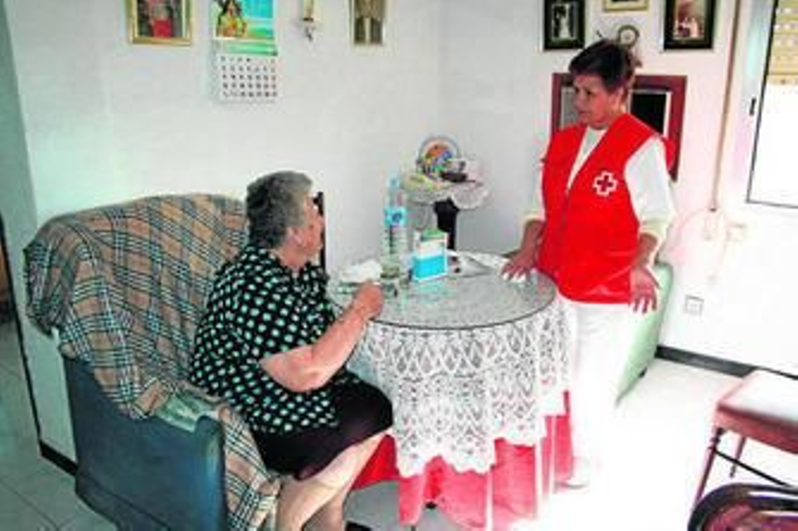 Una usuaria del servicio de teleasistencia conversa con una voluntaria de Cruz Roja.