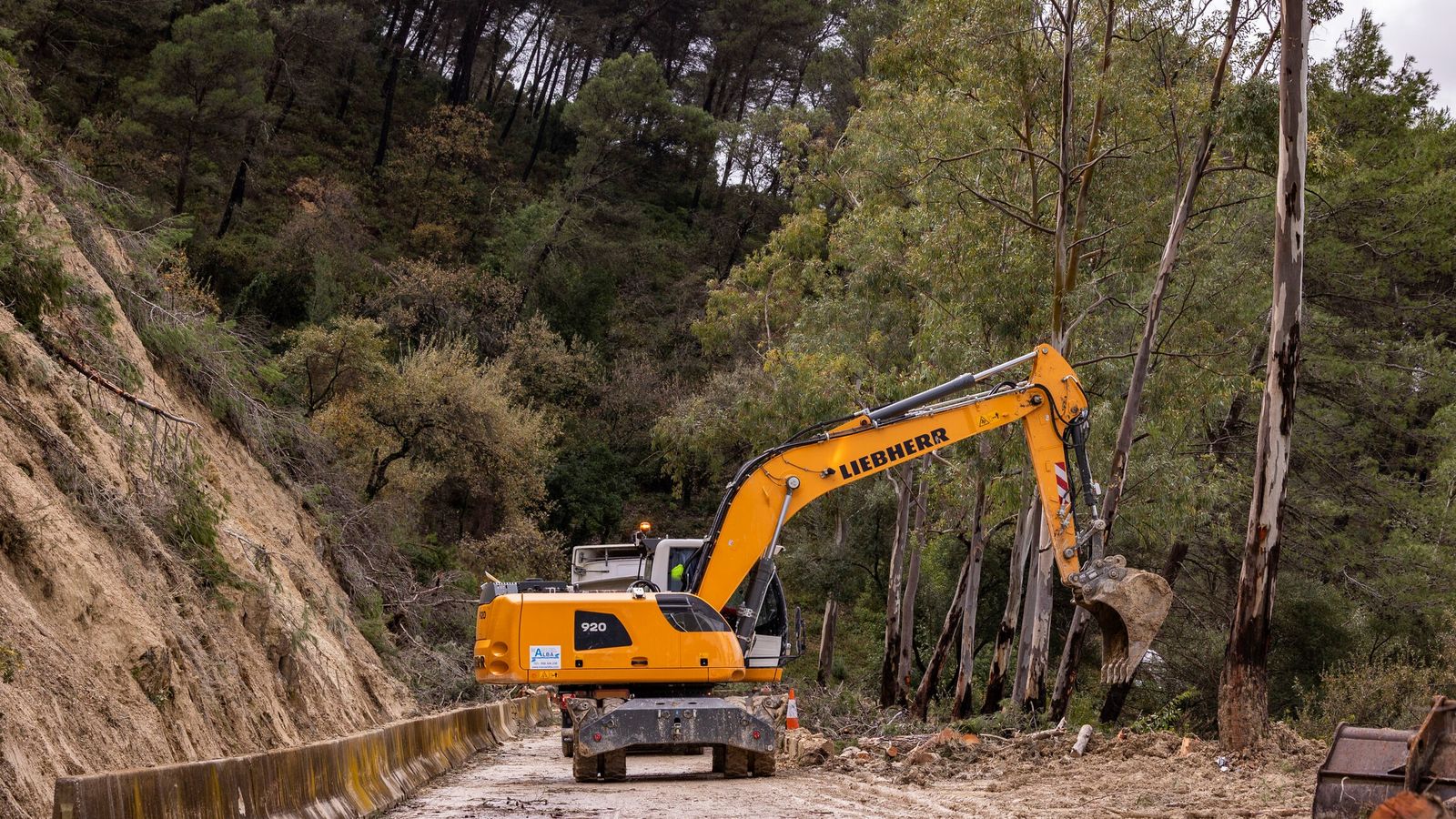 Una excavadora tratando de desbloquear la carretera que lleva a Benamahoma.