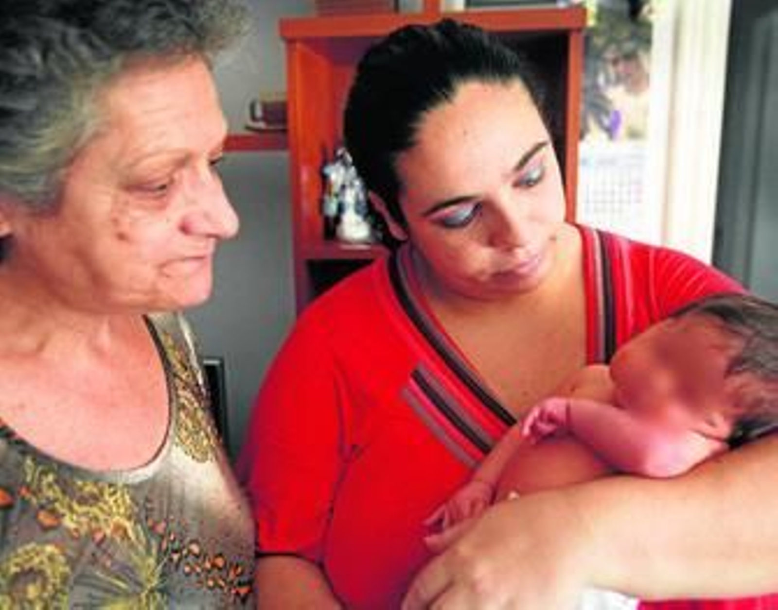 Manuela y Diana observan a Jadel, con 13 días de vida, en su piso de la barriada del Mopu, días atrás.