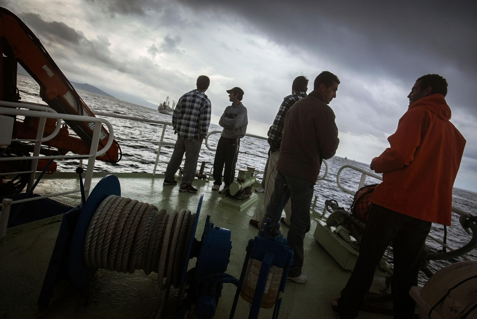 El momento de la partida del puerto de Barbate hacia las aguas marroquíes de Larache con parte de los marineros sobre la proa del pesquero.