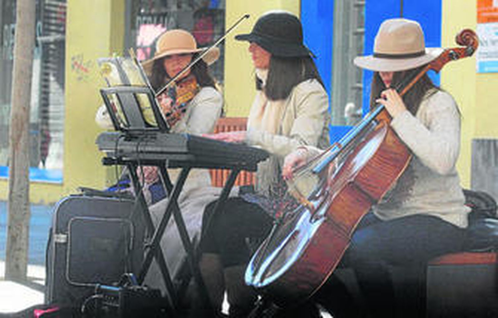 Tres jóvenes interpretan música en la calle Cruz Conde.