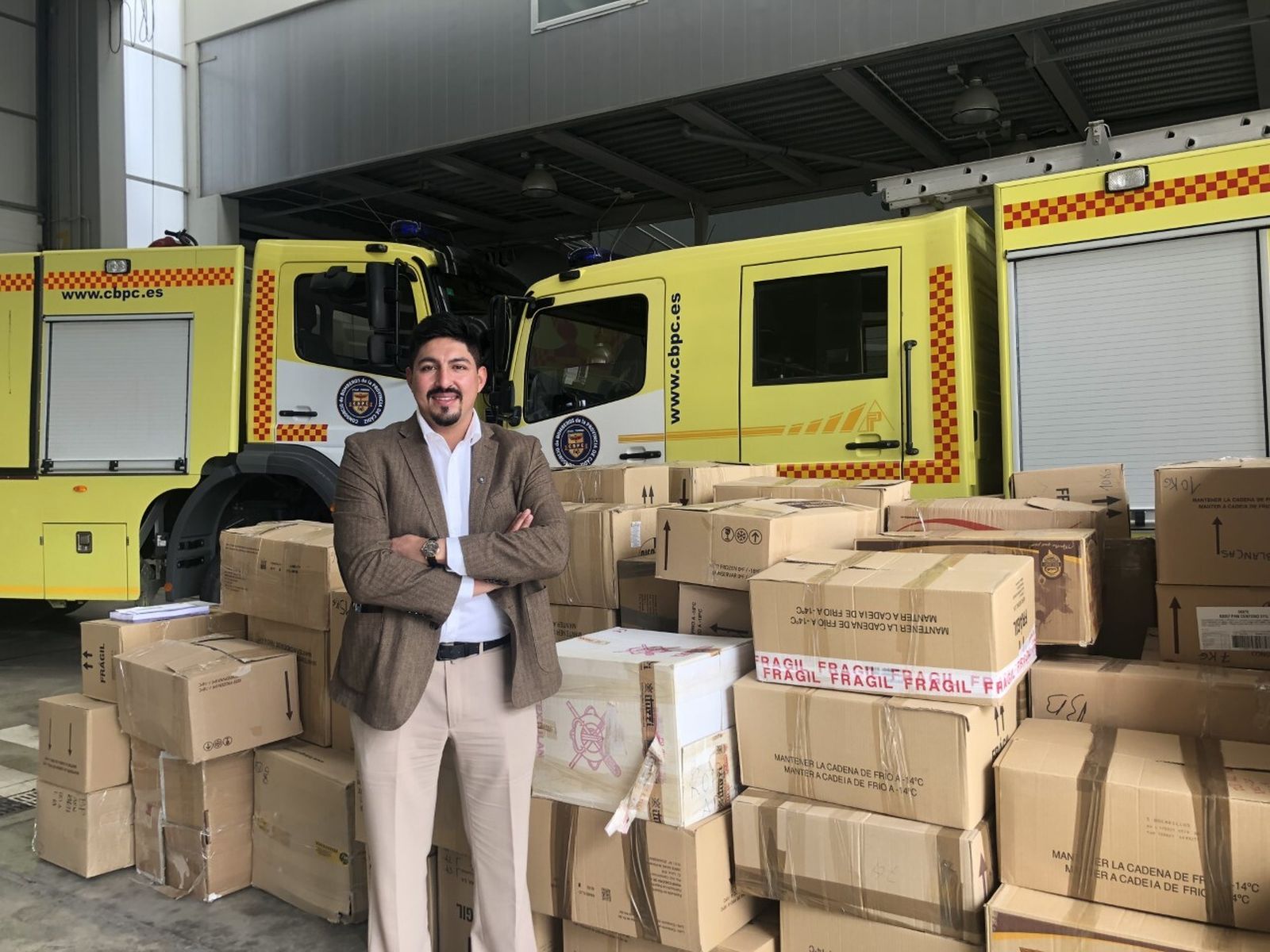 Bismarck Jigena, principal impulsor de la iniciativa, posa en el Parque de Bomberos de Cádiz ante parte de las cajas de material enviadas a Perú y Bolivia.