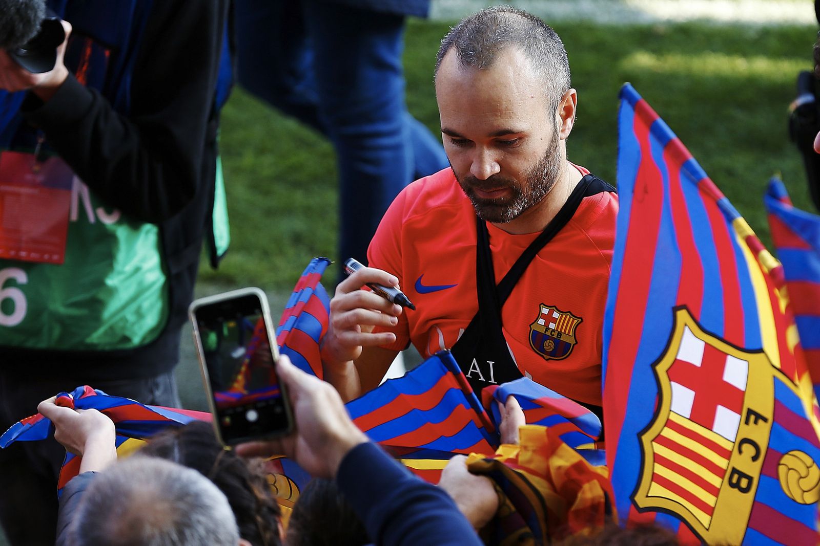 Iniesta firma autógrafos tras el entrenamiento.
