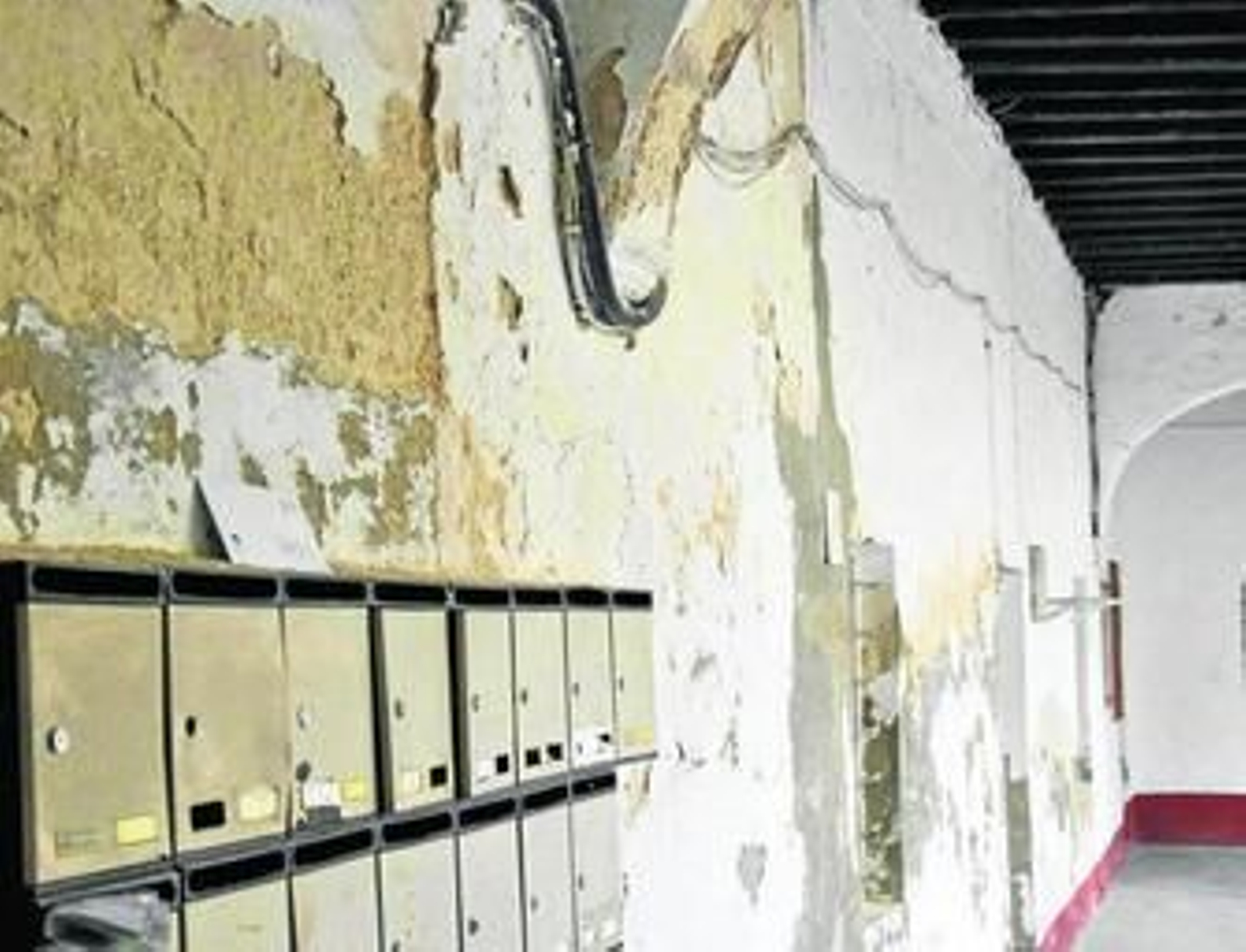 1. En la imagen se puede ver la zona donde se ubican los buzones, con las paredes desprendidas, del Patio de San Francisco. 2. Fotografía tomada desde una planta superior del patio interior, donde algunos vecinos tienden y por donde se cuelan las ratas y los palomos han infestado con sus 'piojillos'. 3. Aspecto de las paredes de un dormitorio de una de las viviendas, donde se crean humedades por la filtración de agua cuando llueve.  FOTOS: JORGE BREA