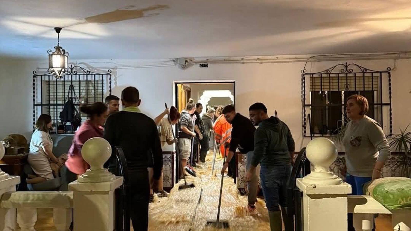 Vecinos achican agua de una vivienda anegada.