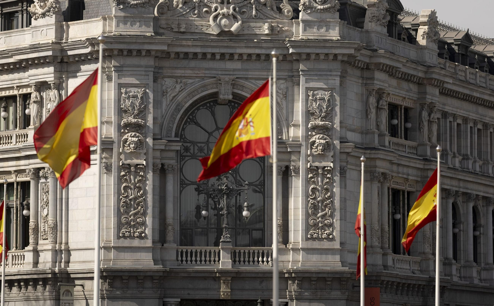 Varias banderas del país frente a la fachada del Banco de España.