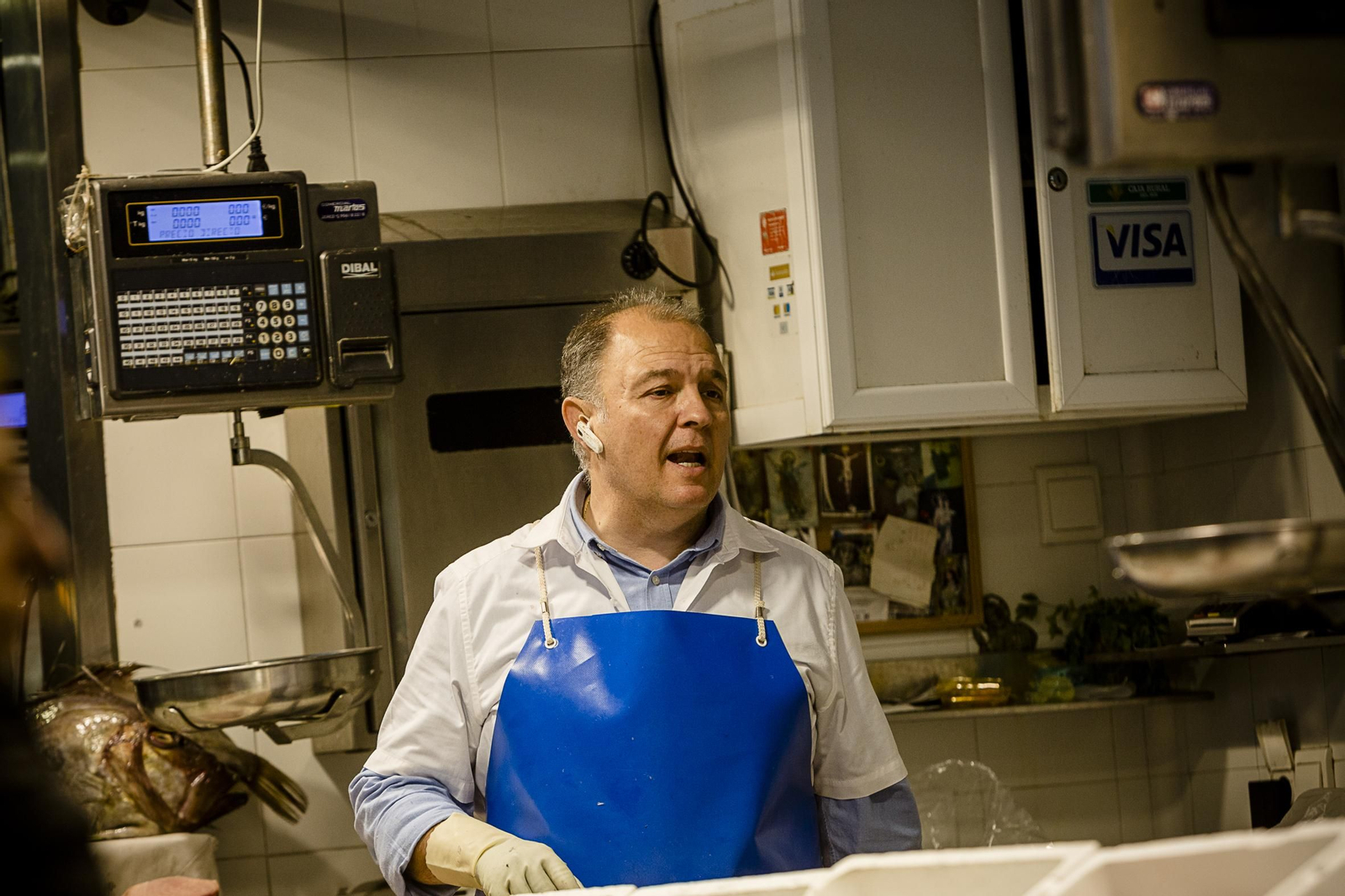 Un pescadero atiende por teléfono un pedido a domicilio