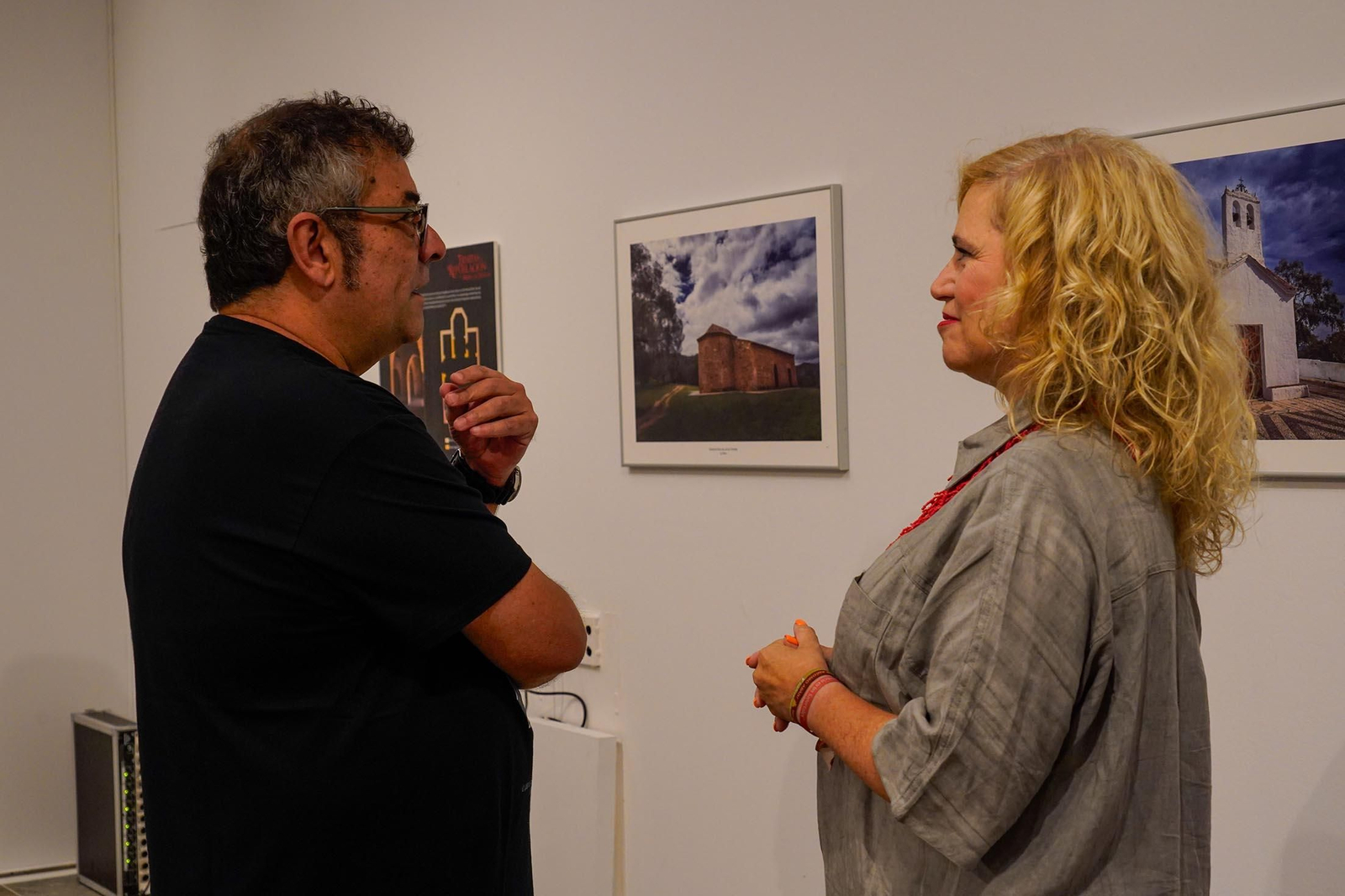 Imágenes de la inauguración de la exposición 'Ermitas de repoblación en la Sierra de Huelva' por La diputada de Cultura, Gracia Baquero, y el autor de la exposición, Jorge Garrido.