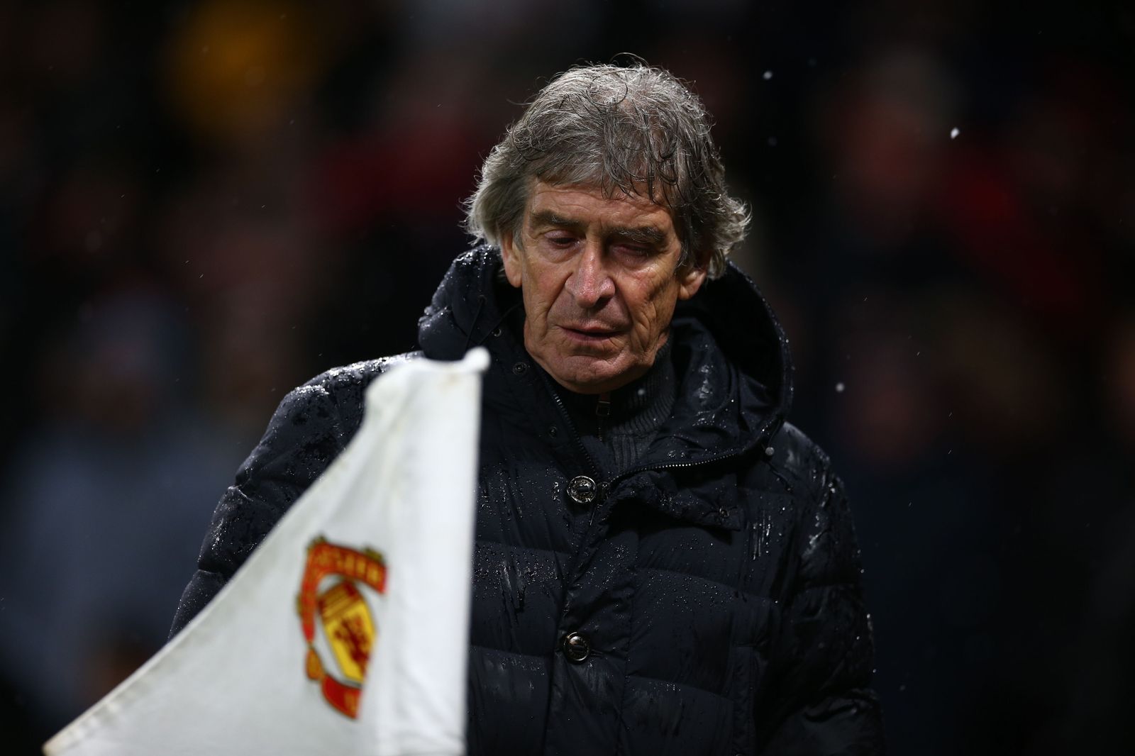 Manuel Pellegrini, tras un banderín de córner con el escudo del United.