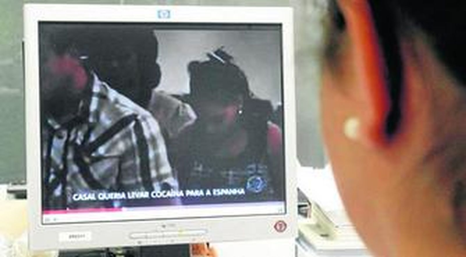 Una joven ve el vídeo de la detención de la pareja sevillana publicado por una televisión brasileña.