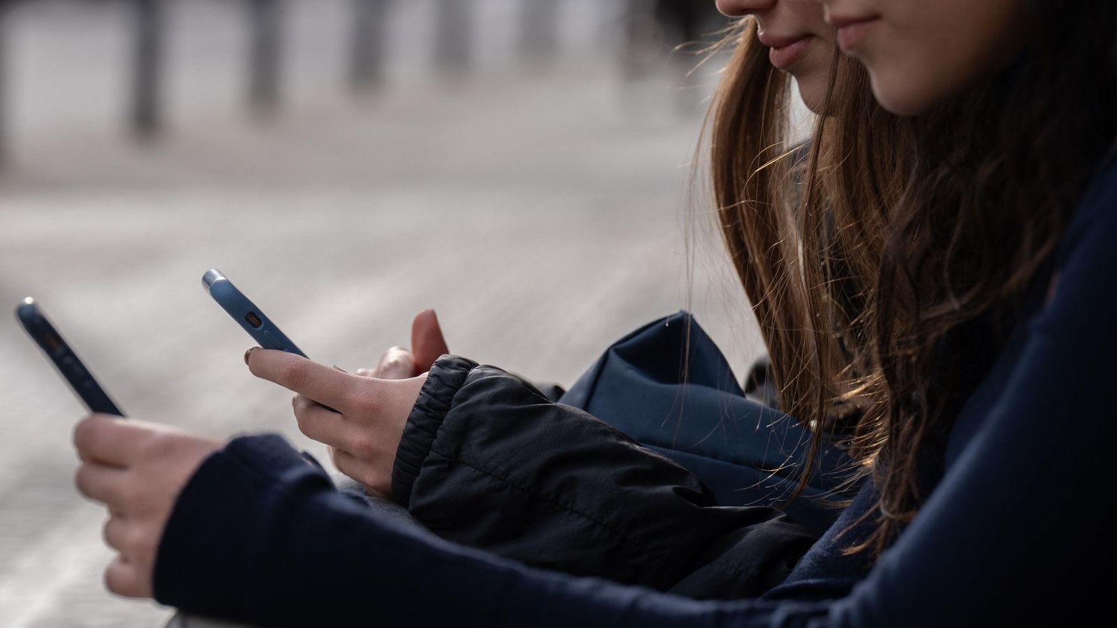 Dos personas usan el teléfono móvil.