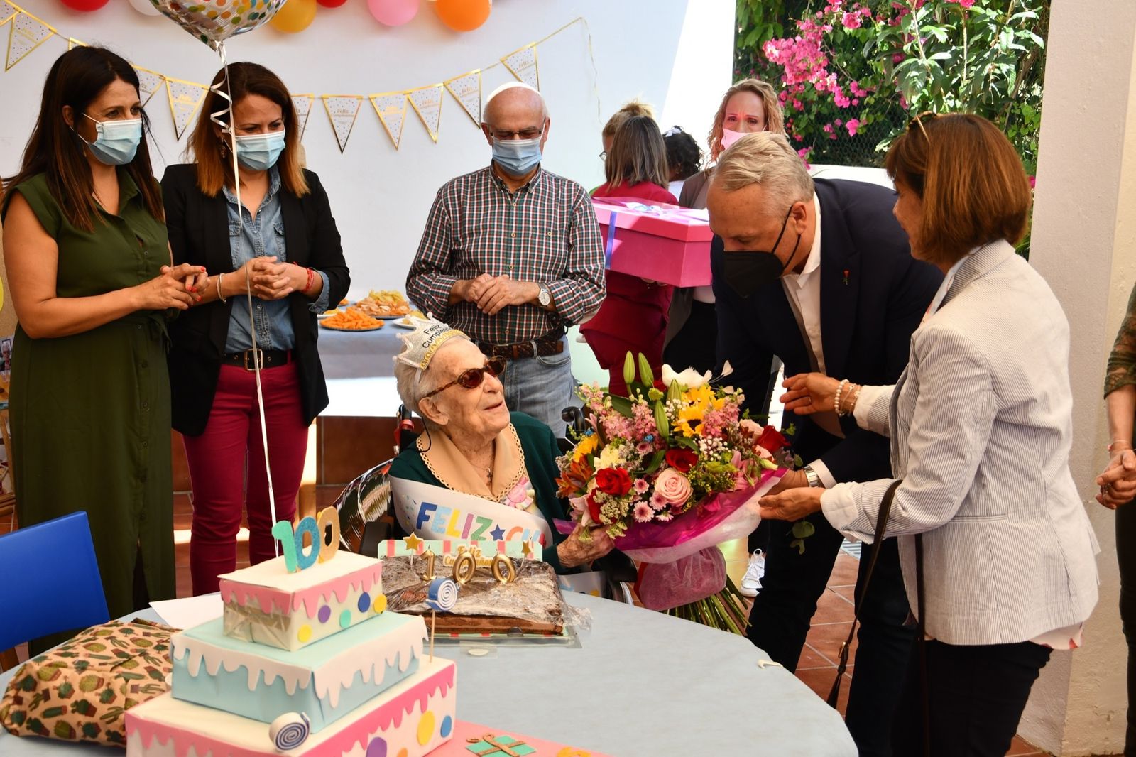 María Luisa Baños recibe un ramo de flores por sus 100 años.