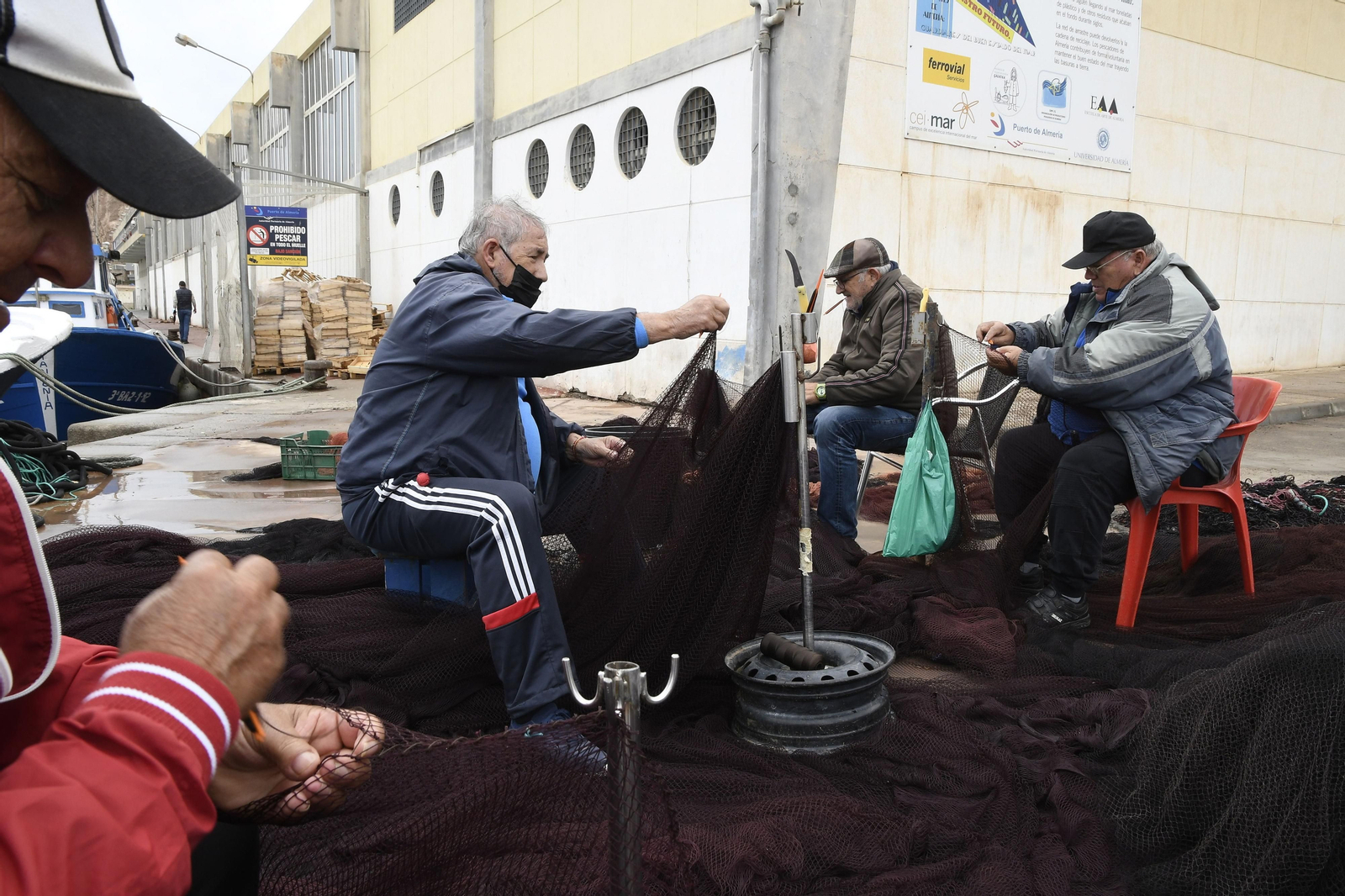 Pescadores arreglan sus aparejos en el puerto de Almería