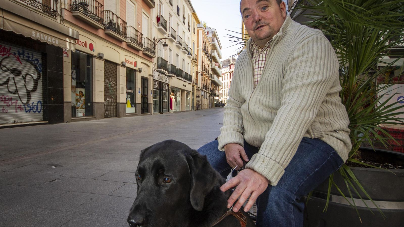 El granadino posa junto a su can, sus ojos en la calle.