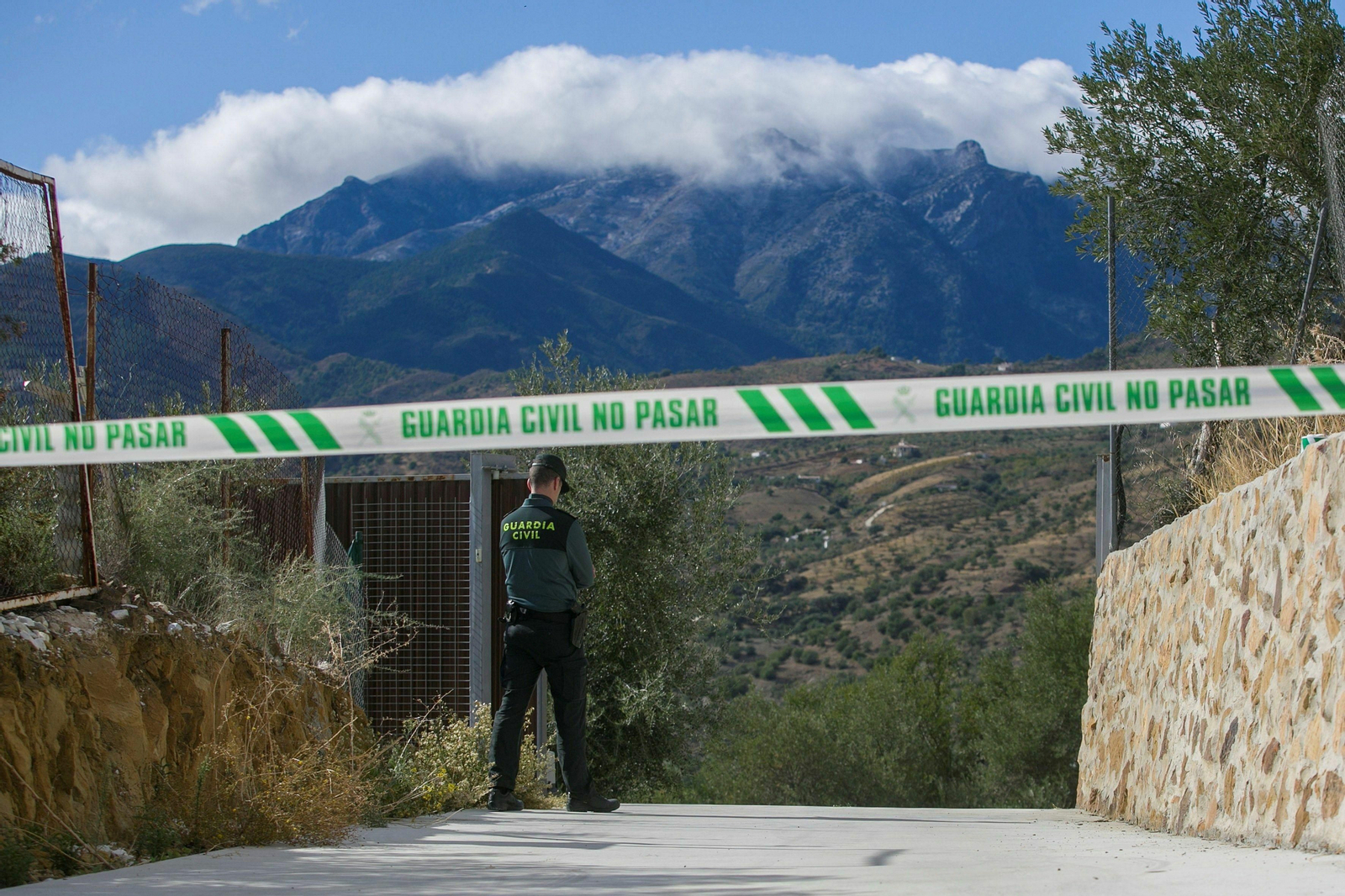 Un guardia civil custodia el acceso a la vivienda de la mujer fallecida en Tolox
