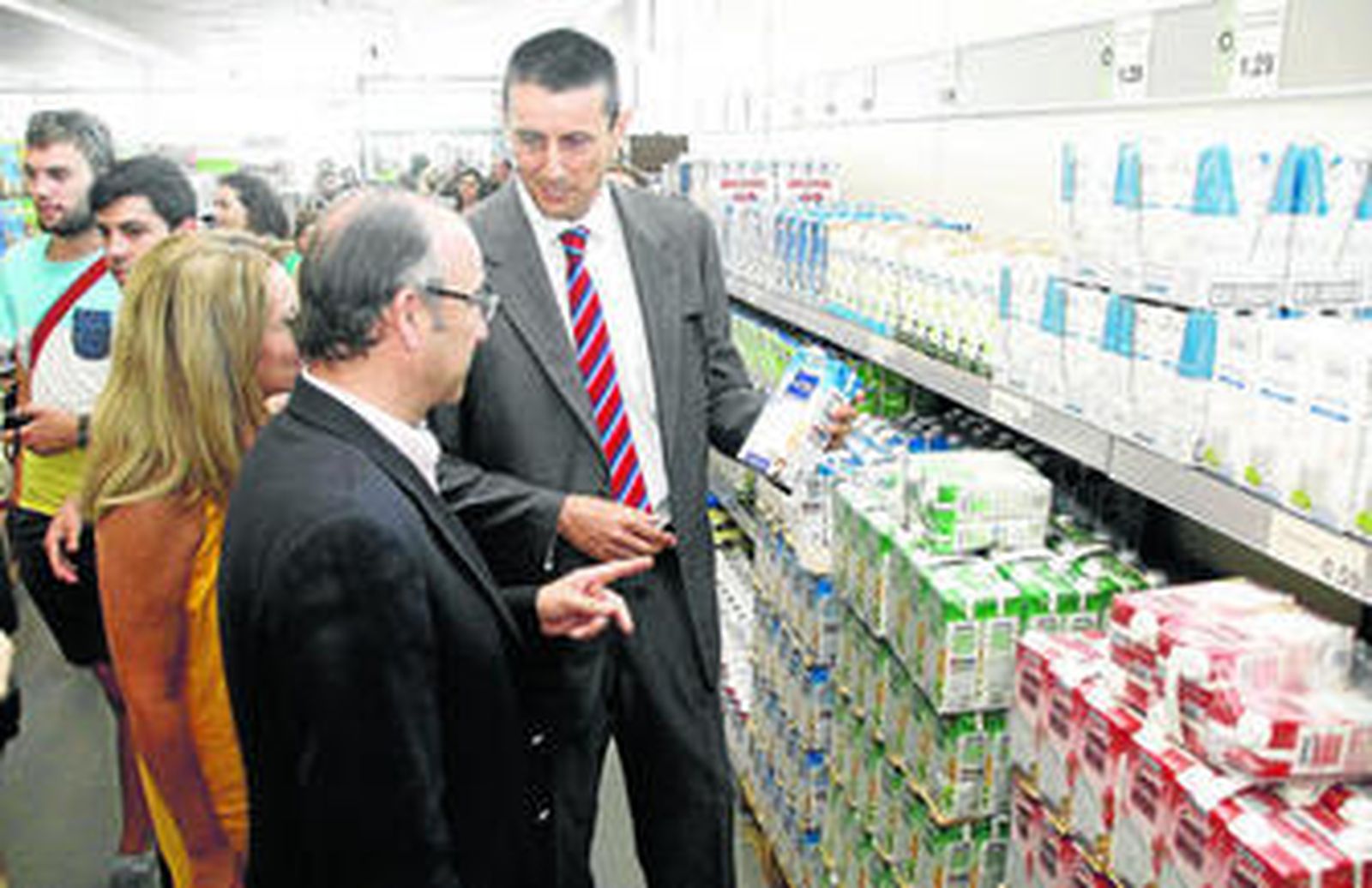 Luis Rogelio y Miguel Colomar observan los cartones de leche durante la visita.