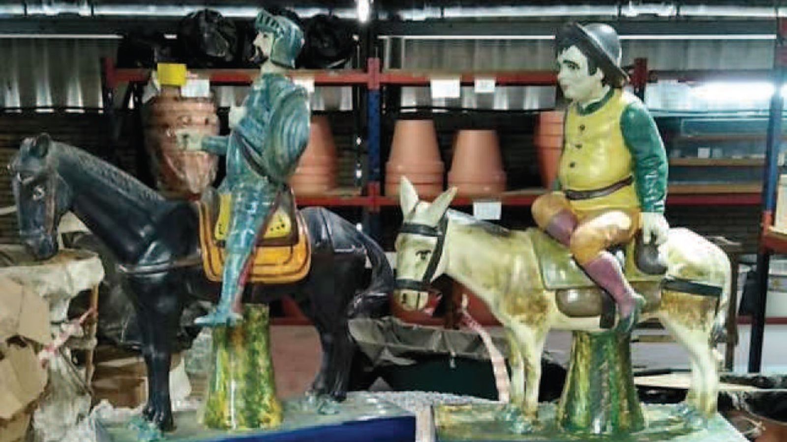 Las figura de don Quijote y Sancho Panza que remataban los anaqueles.