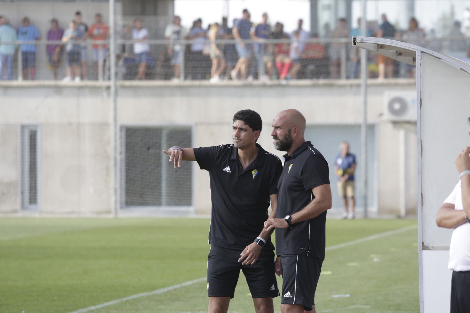 Juanma Pavón (i) junto a su ayudante, Raúl López, en la zona de banquillos del campo Ramón Blanco.
