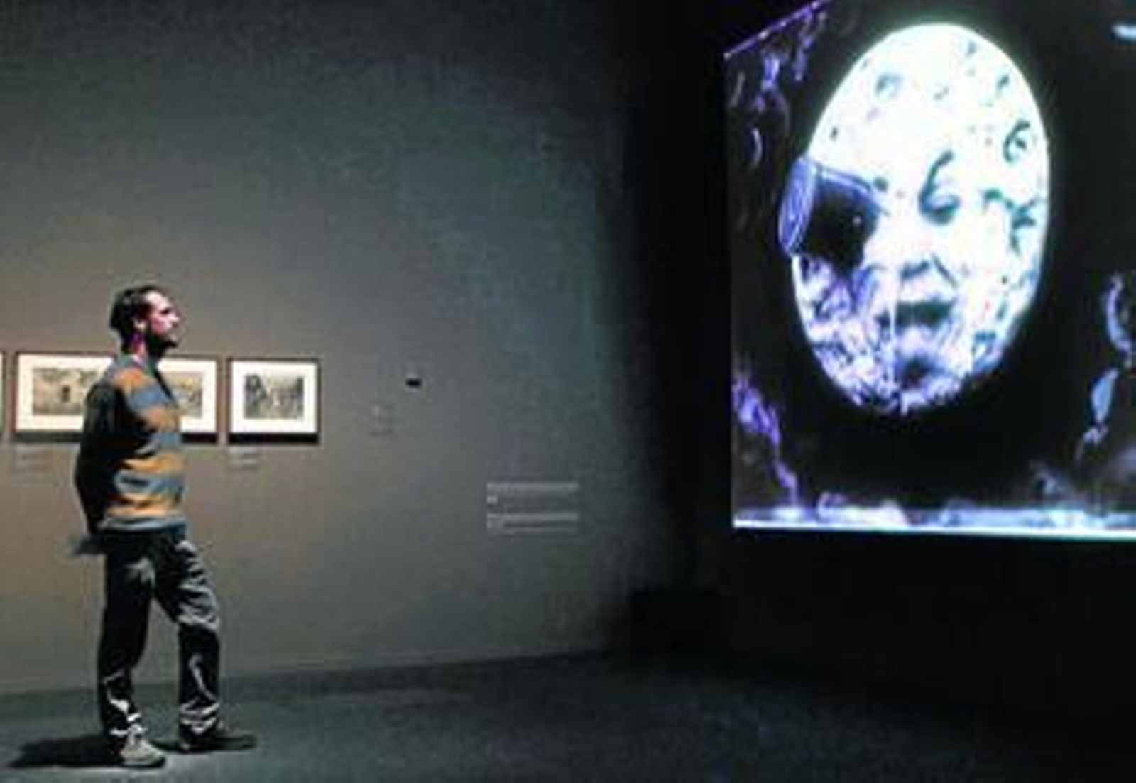 Un visitante observa la proyección de 'Viaje a la luna', de George Méliès.