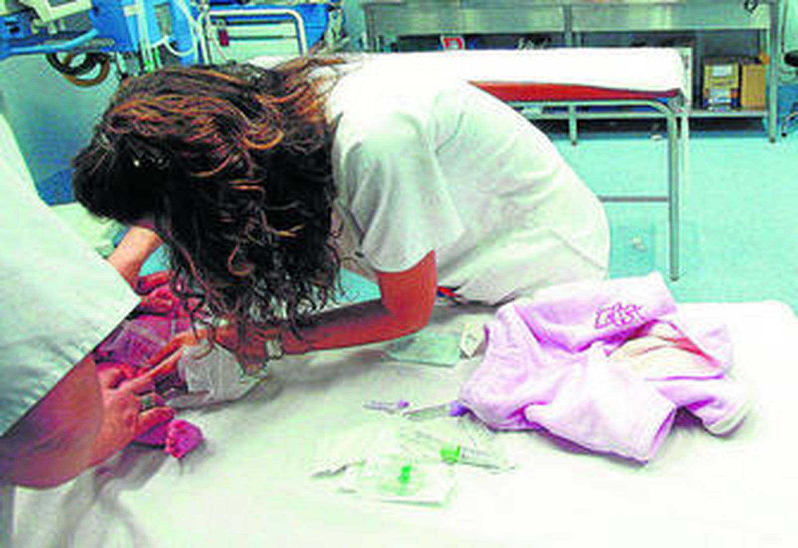 Un bebé es atendido por una profesional en un centro sanitario.