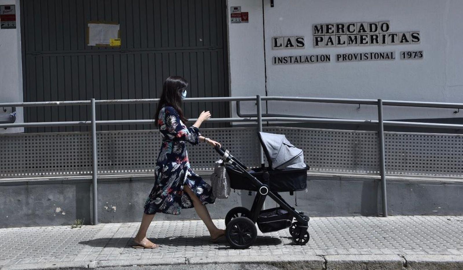 Una mujer pasa por la puerta del mercado de Las Palmeritas, cerrado por el Ayuntamiento.