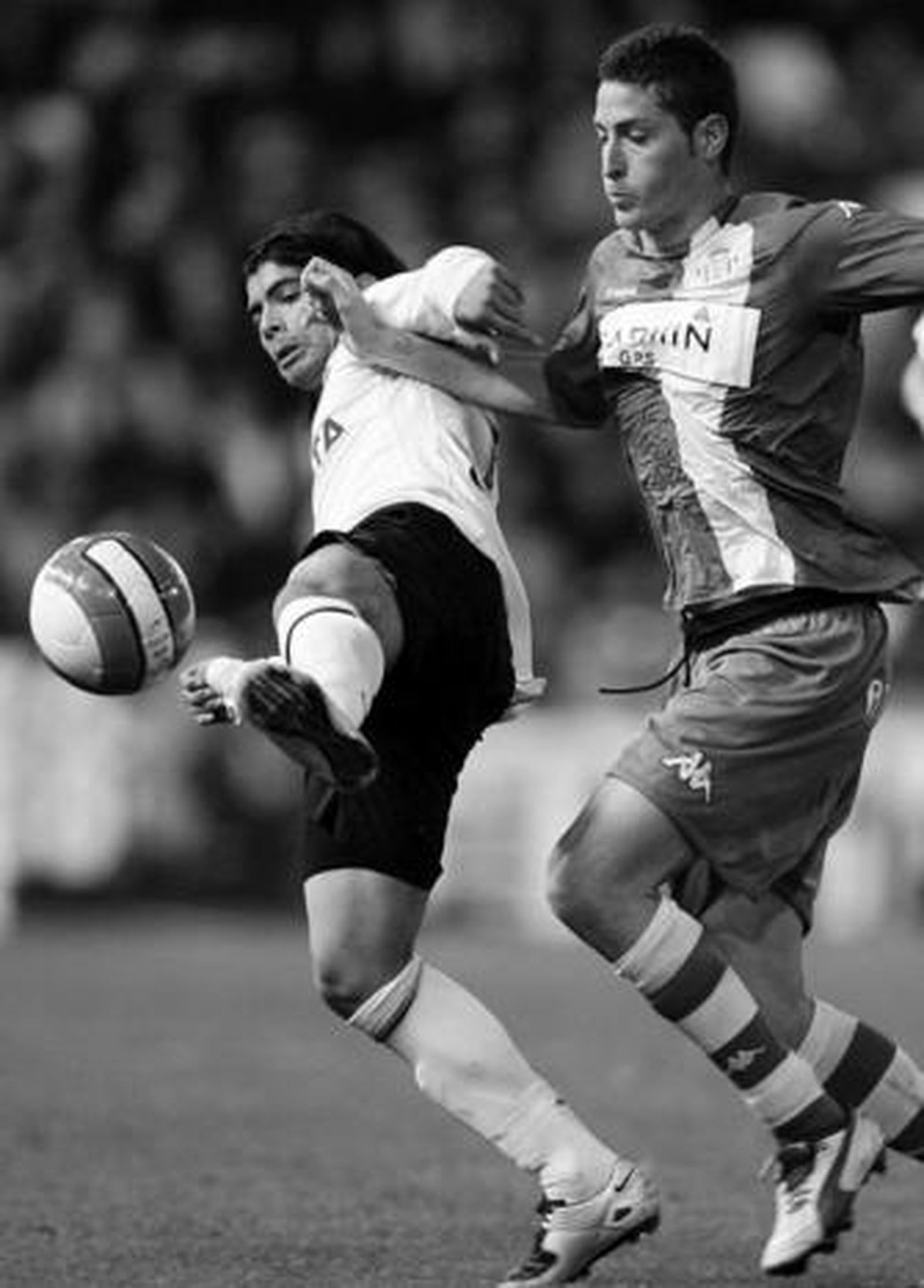 Damià pugna un balón con Banega metiéndole el brazo en el cuerpo.