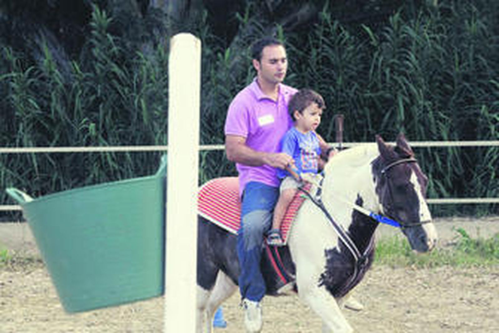 José Antonio Moya pasea a un niño por el picadero del Centro de Hipoterapia de la Fundación Santa María Polo.