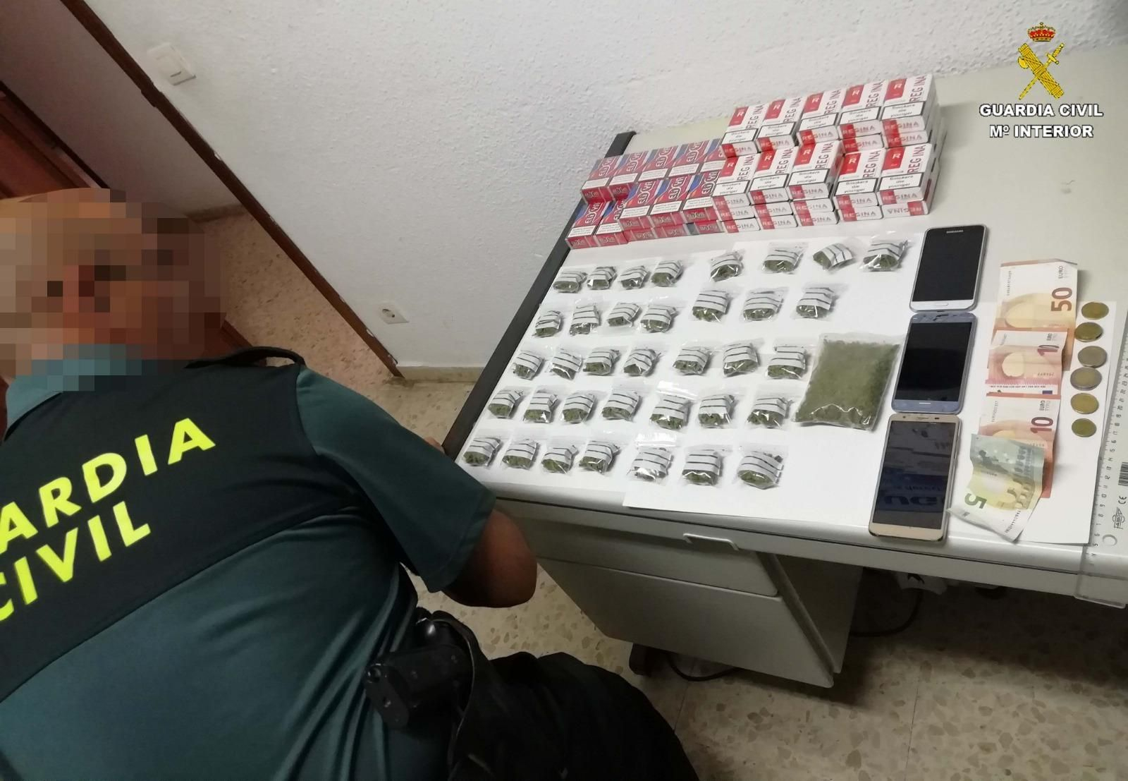 Un agente de la Guardia Civil ante la droga incautada en Palos de la Frontera.