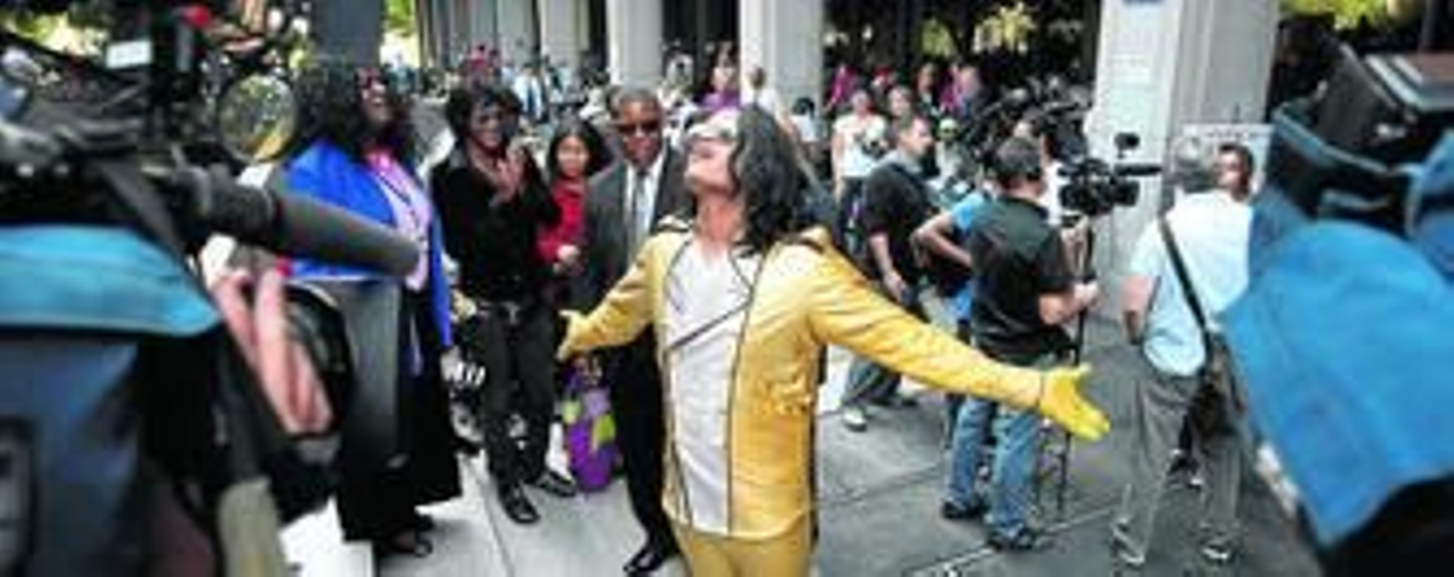 Un actor caracterizado como Michael Jackson hace su espectáculo frente a las cámaras apostadas a las puertas de los juzgados de Los Ángeles.