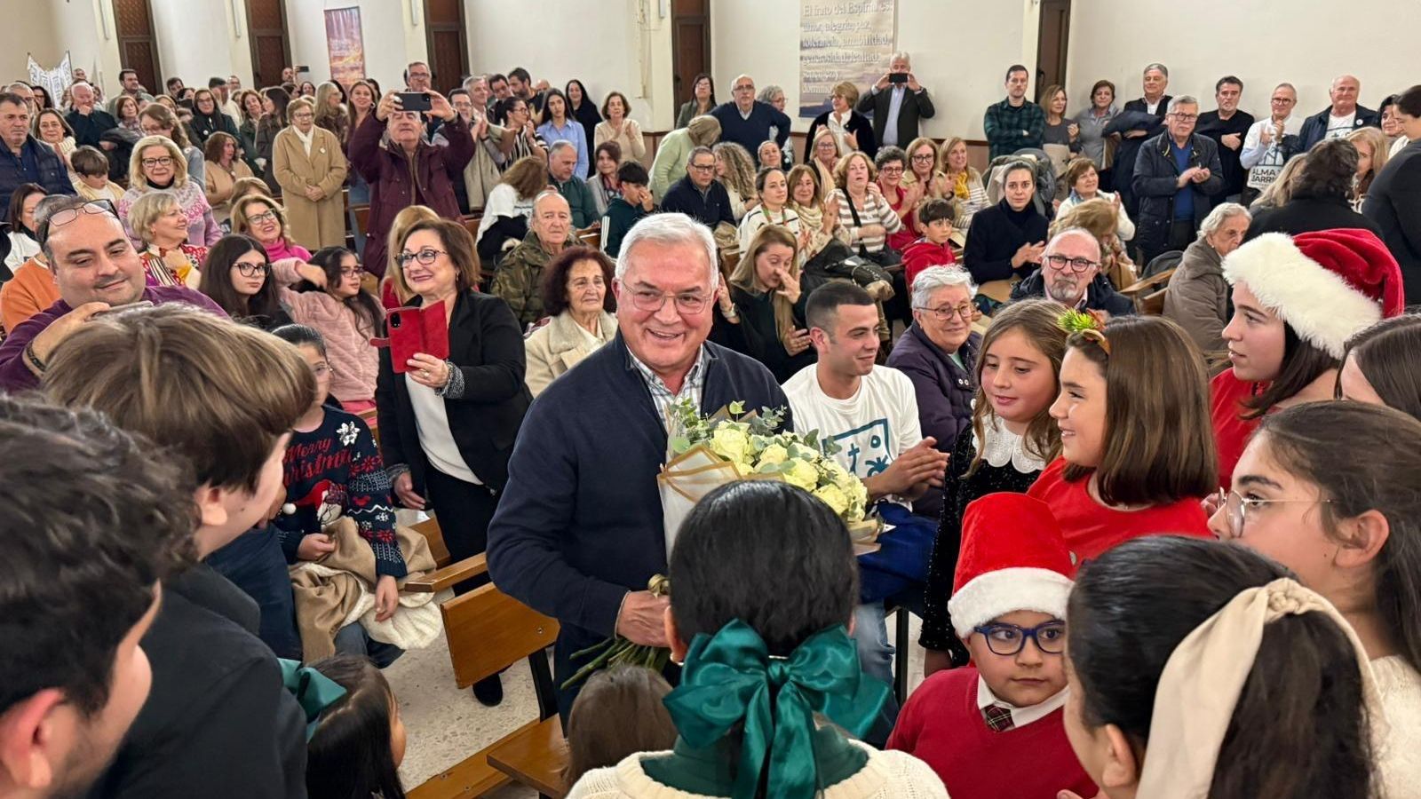El padre Pedro, rodeado de fieles en su iglesia.