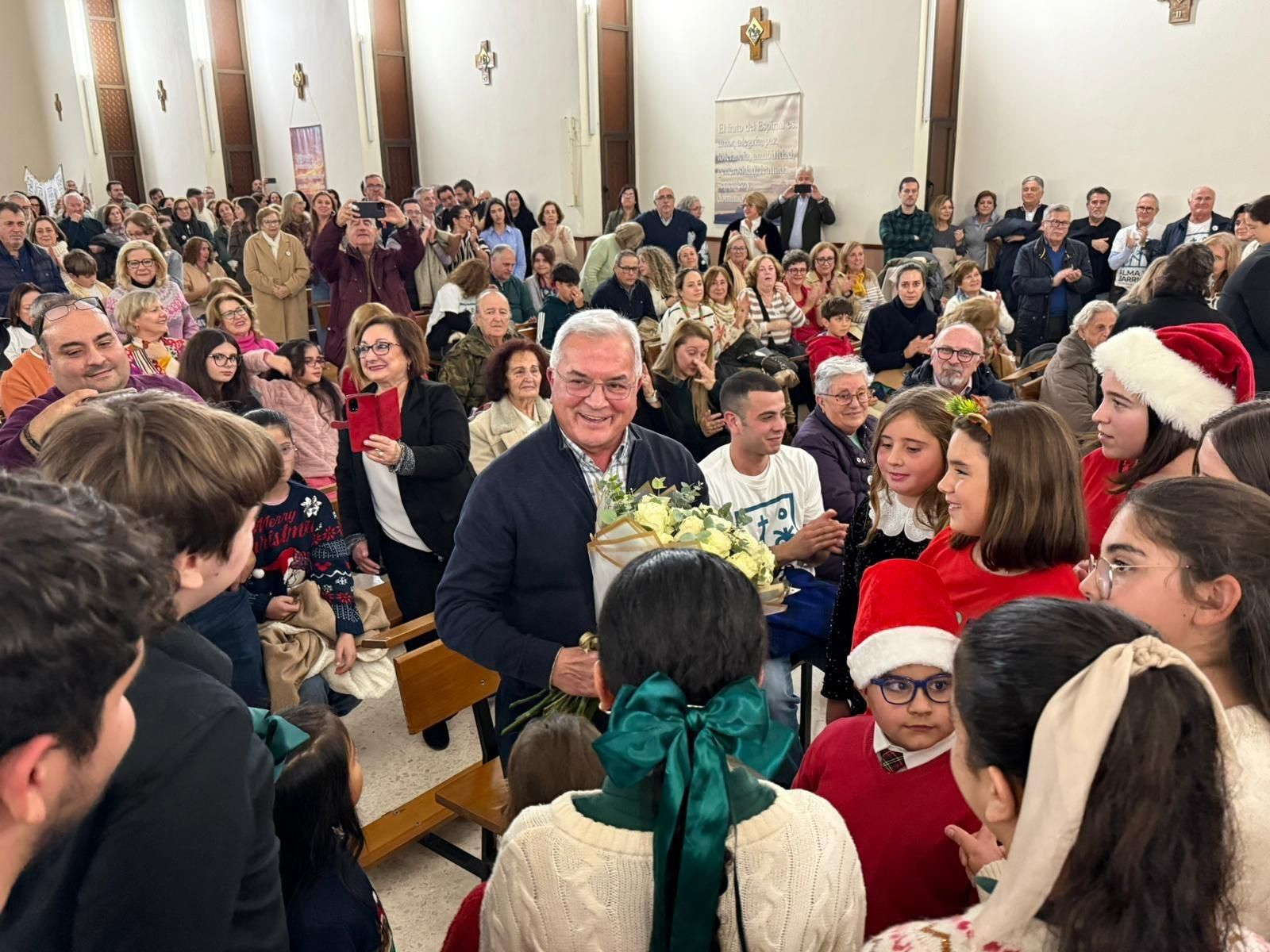 El padre Pedro, rodeado de fieles en su iglesia.