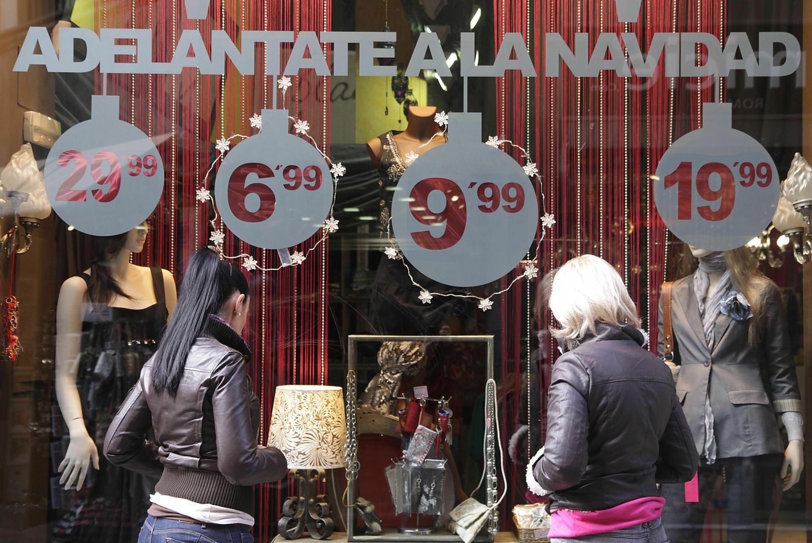Dos mujeres observan el escaparate de una tienda en Navidad.