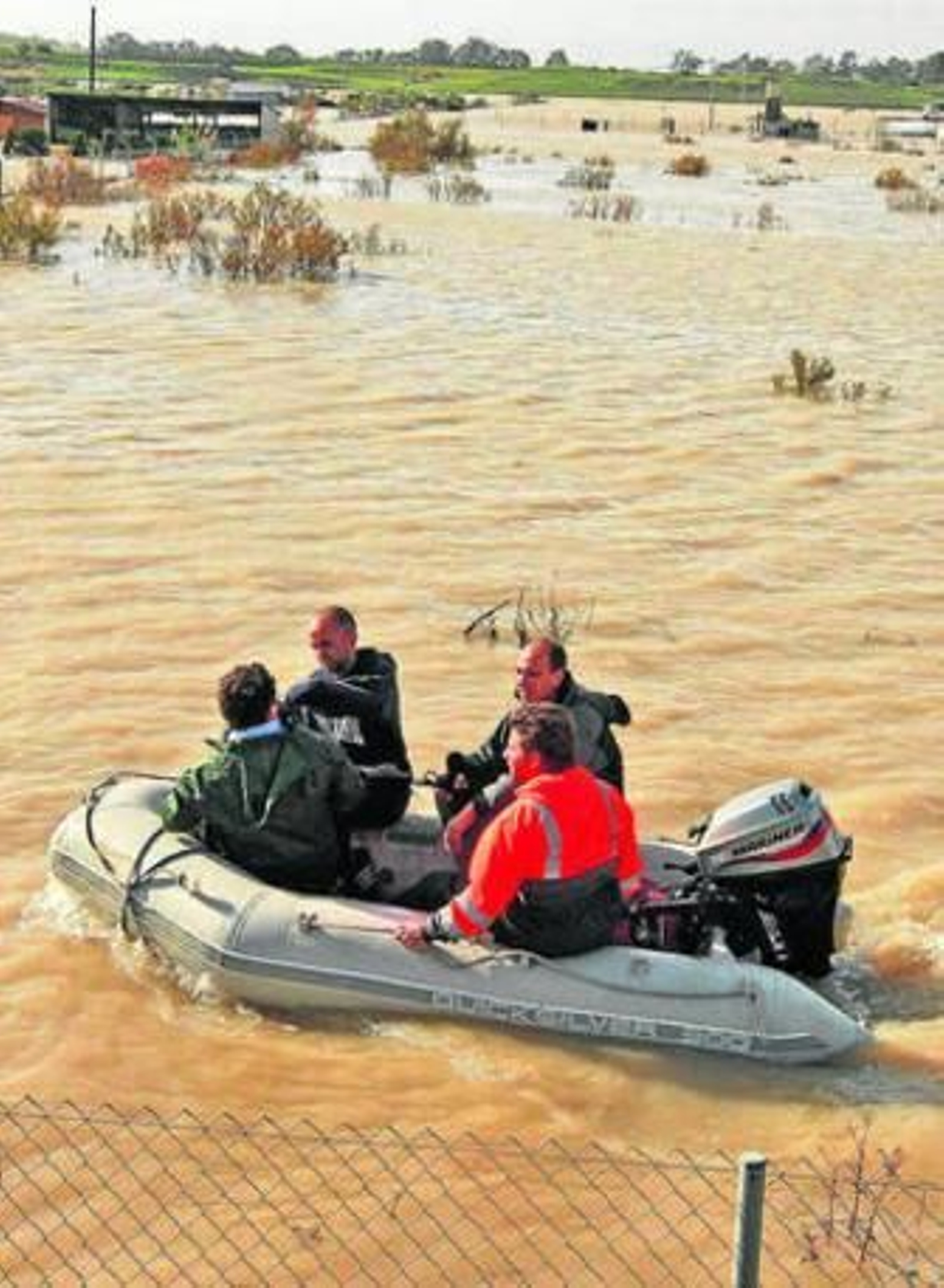 Vecinos cruzan en zodiac las parcelas de cultivo anegadas en La Ina.