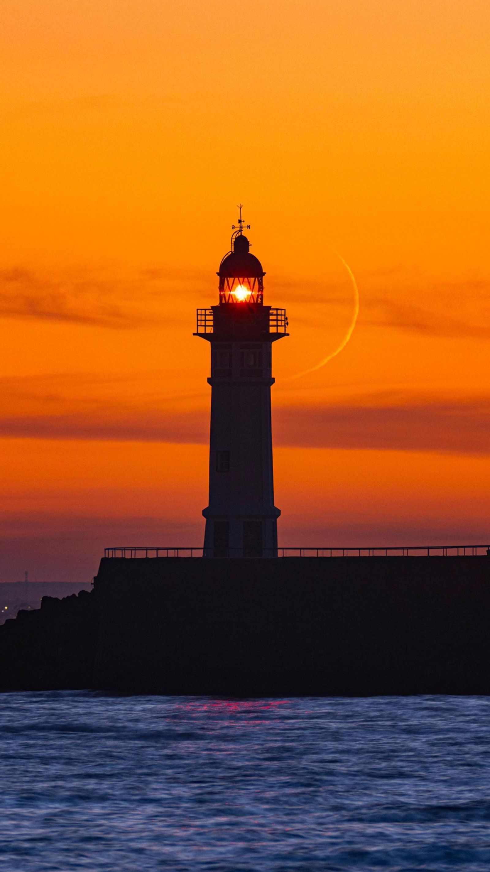El icónico faro del puerto de la capital con la luz crepuscular.