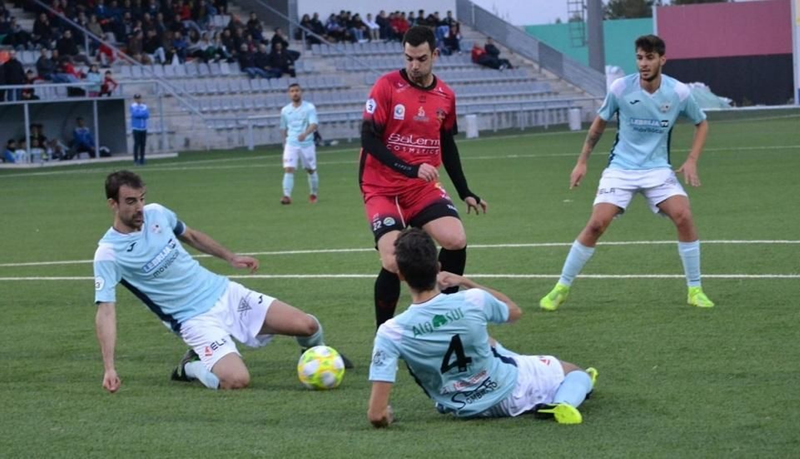 Juan Delgado se topa con dos defensas de la Lebrijana en el área sevillana.