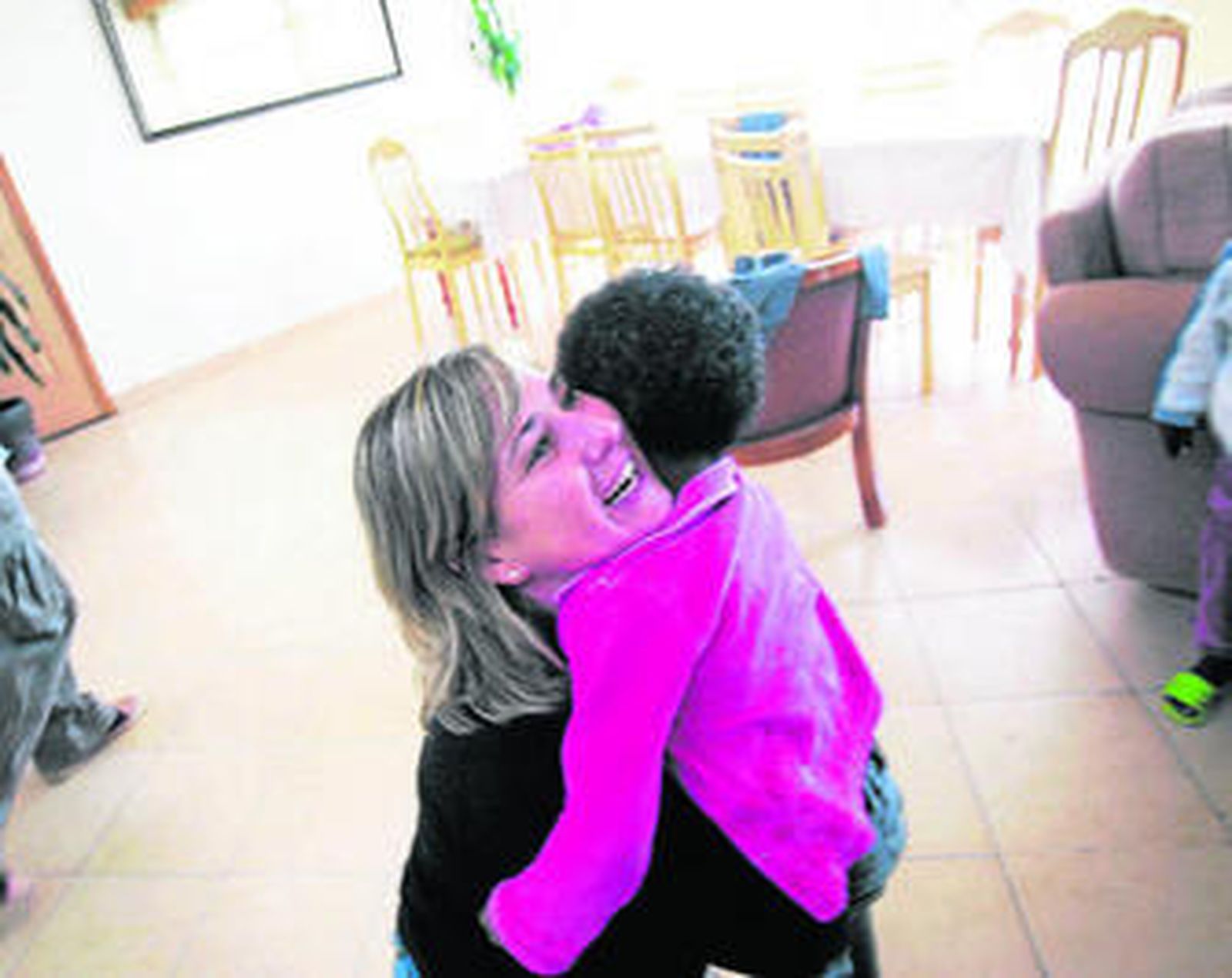 Una mujer abraza a un menor procedente de la adopción internacional.