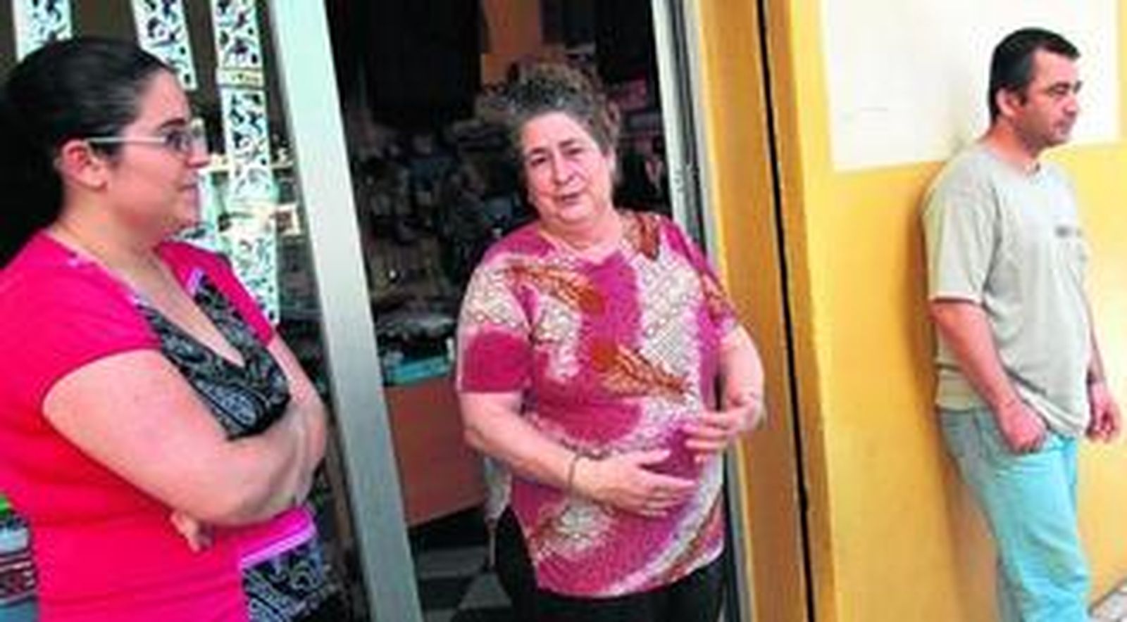 Remedios Zambrana, en la puerta de su droguería, junto a su hijo.